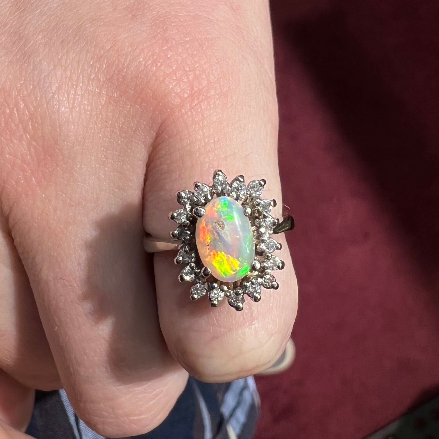 A white crystal opal ring cast in white gold with a halo of round cut diamonds.