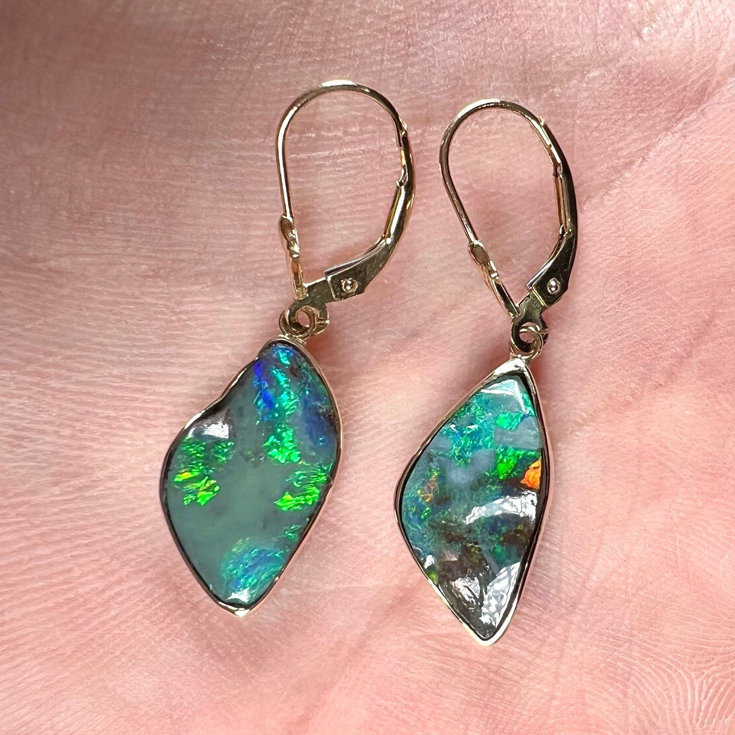A pair of yellow gold dangle earrings set with Australian boulder opal stones.