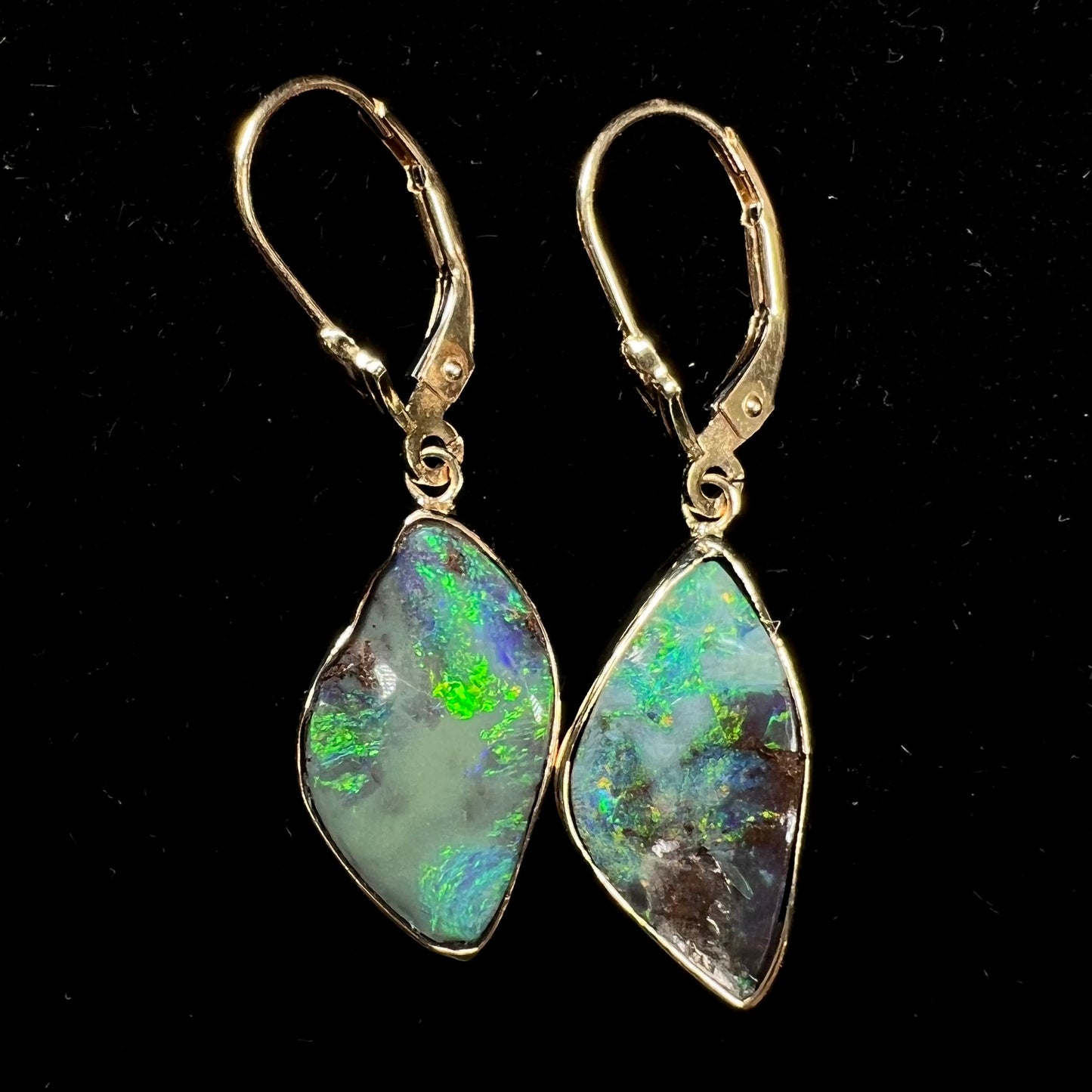 A pair of yellow gold dangle earrings set with Australian boulder opal stones.