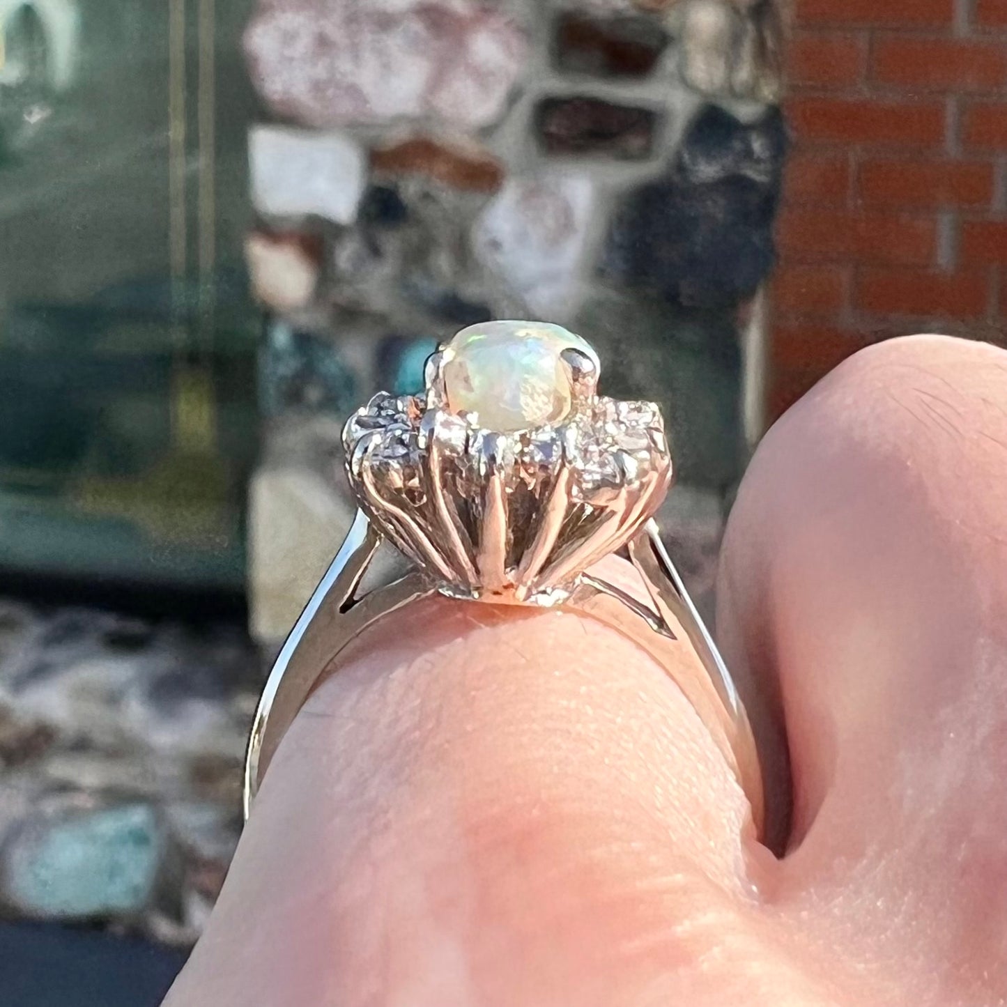 A white crystal opal ring cast in white gold with a halo of round cut diamonds.