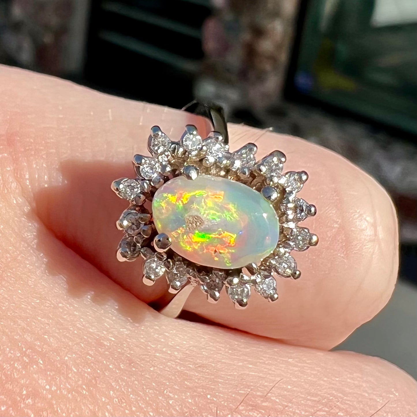 A white crystal opal ring cast in white gold with a halo of round cut diamonds.
