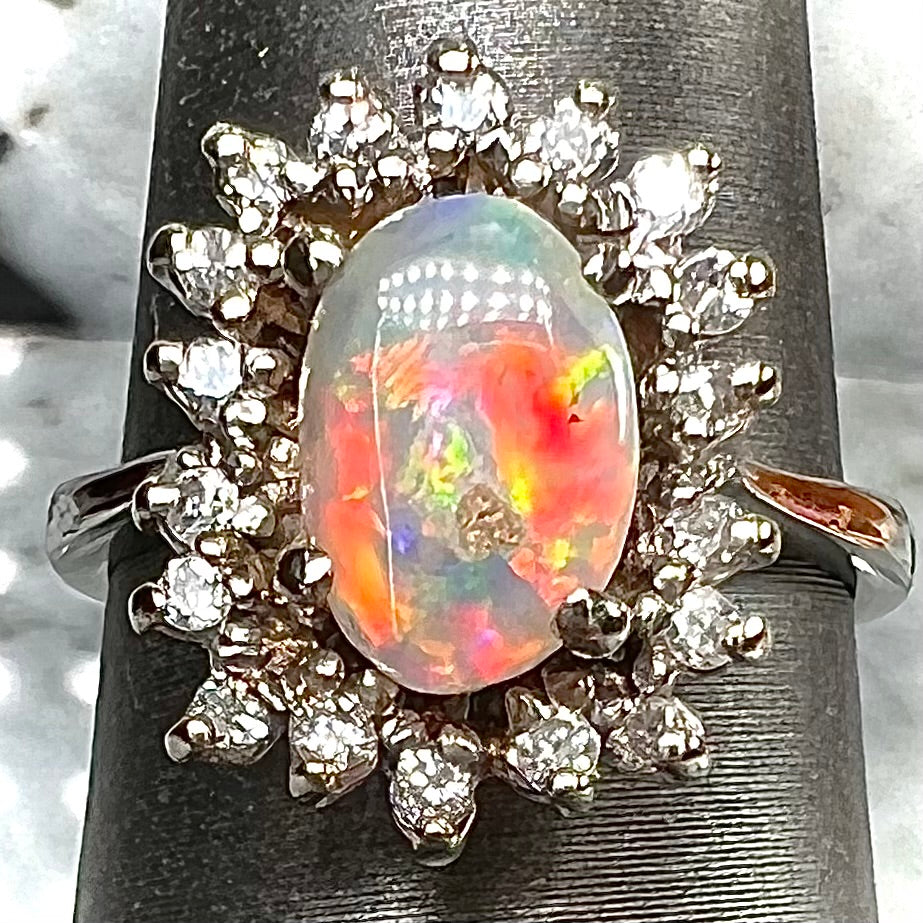 A white crystal opal ring cast in white gold with a halo of round cut diamonds.