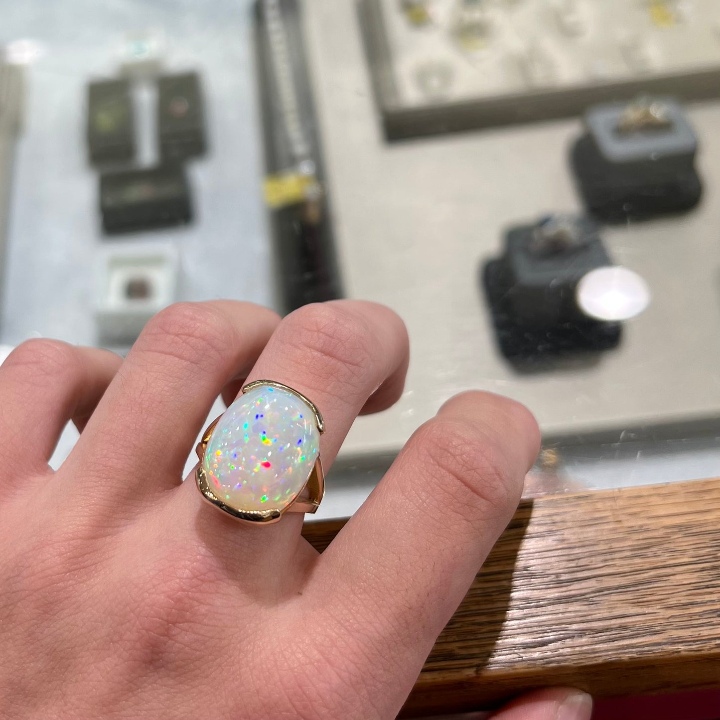 A ladies' yellow gold split shank ring half-bezel set with a barrel cabochon cut natural Ethiopian fire opal stone.