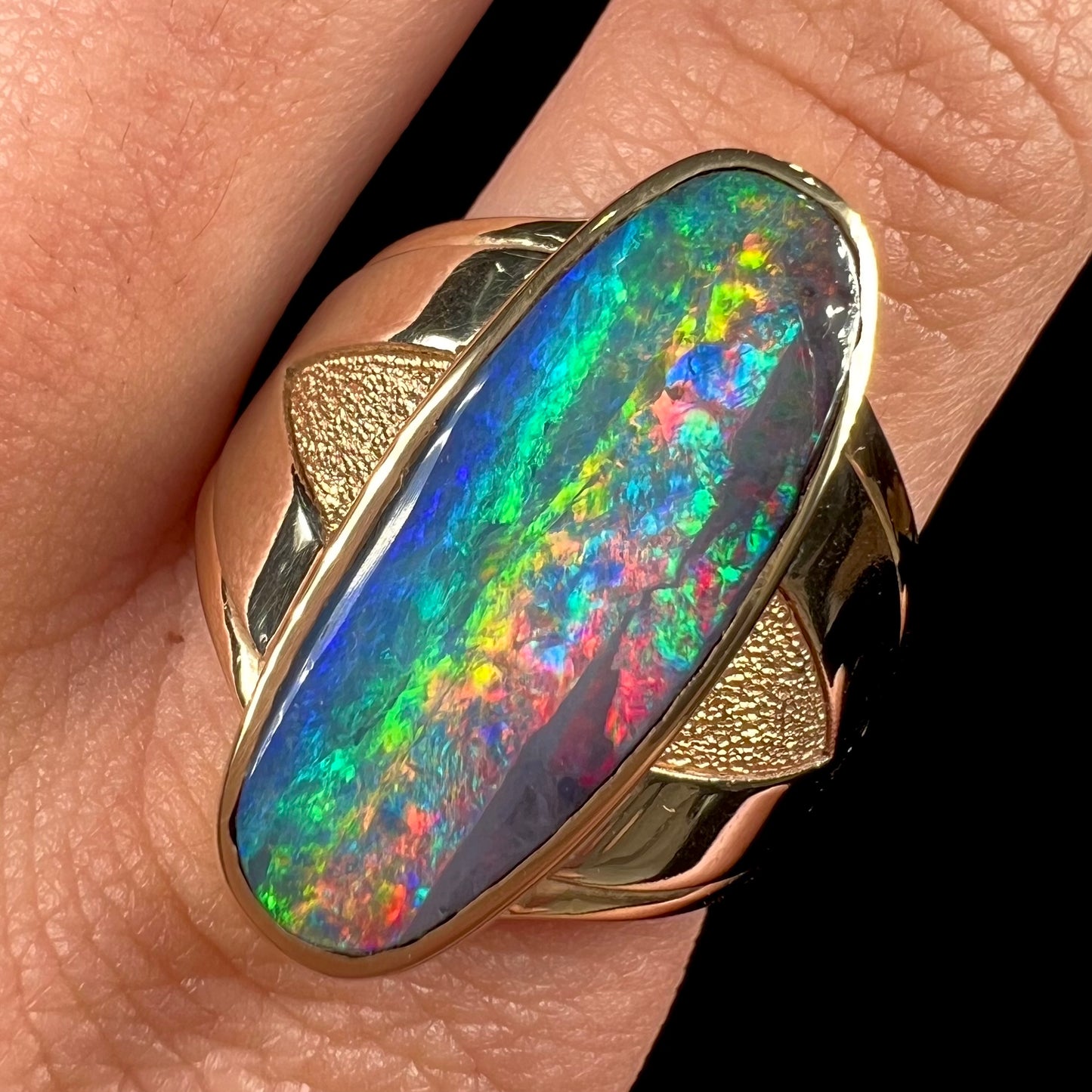 A men's two-tone gold solitaire ring set with a natural boulder opal from Koroit Mining District, Australia.