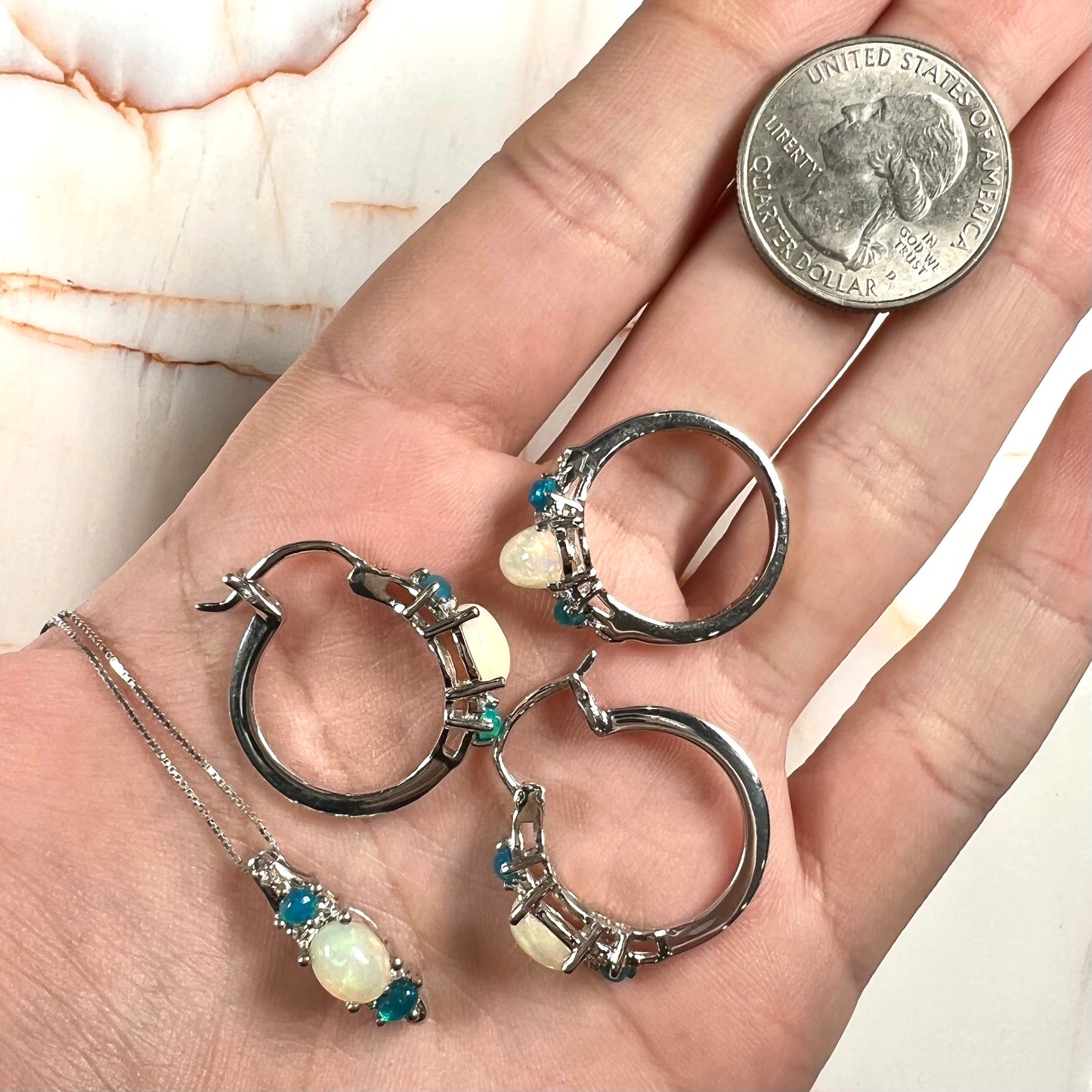 A sterling silver ring, earring, and necklace set made of Ethiopian opals and cubic zirconia.