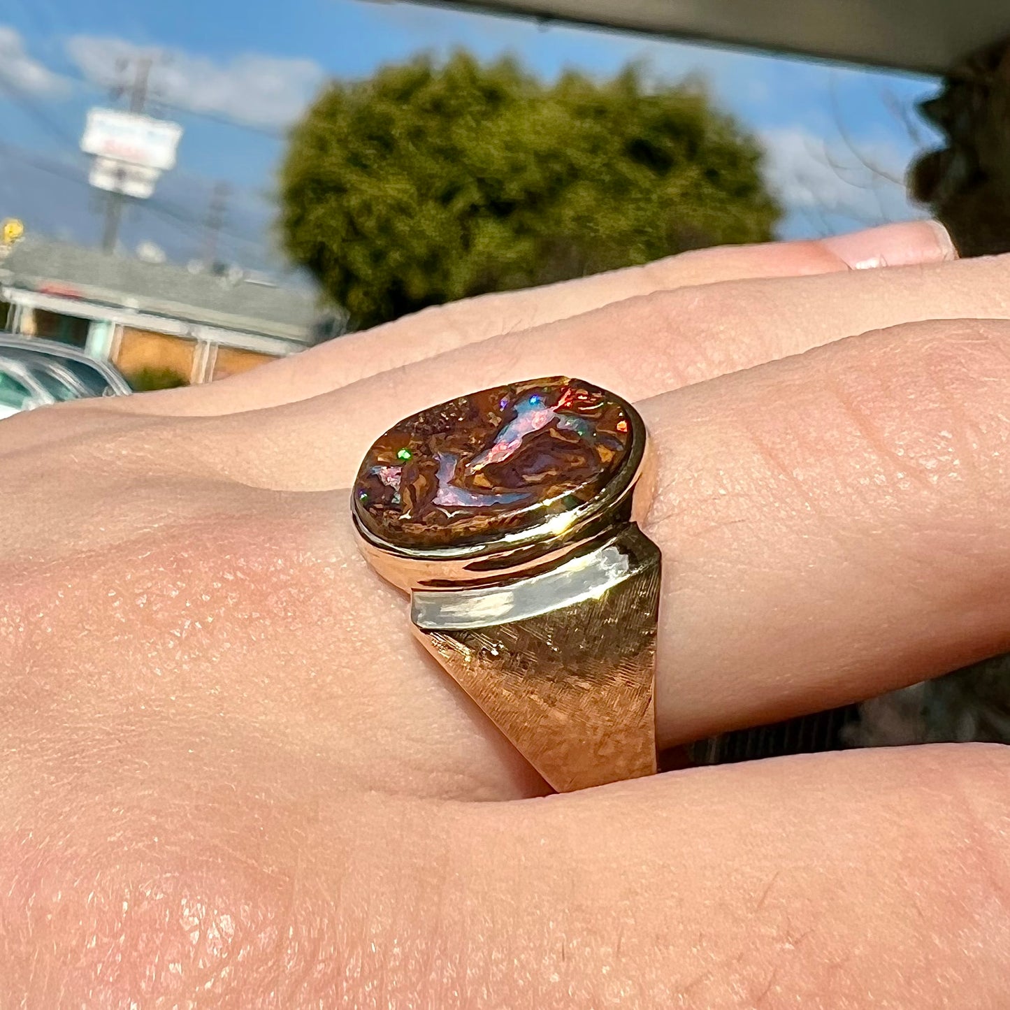 A Koroit boulder opal men's ring in brushed yellow gold.