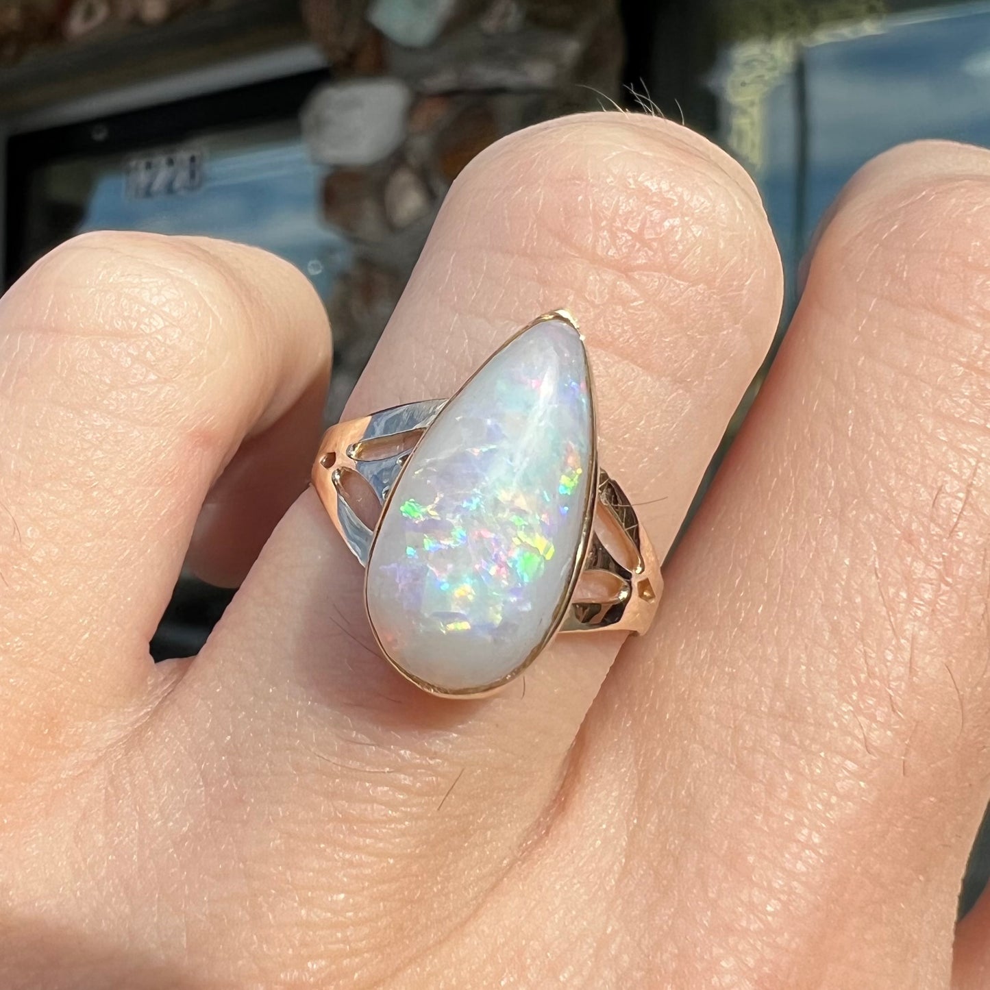 A ladies' pear shaped white crystal opal solitaire ring handmade in yellow gold.