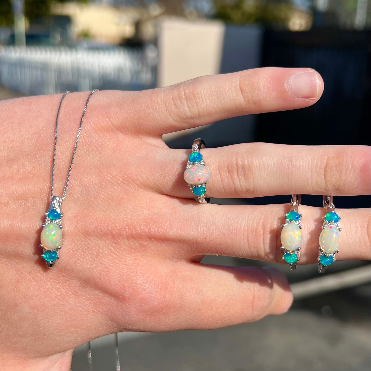 A sterling silver ring, earring, and necklace set made of Ethiopian opals and cubic zirconia.