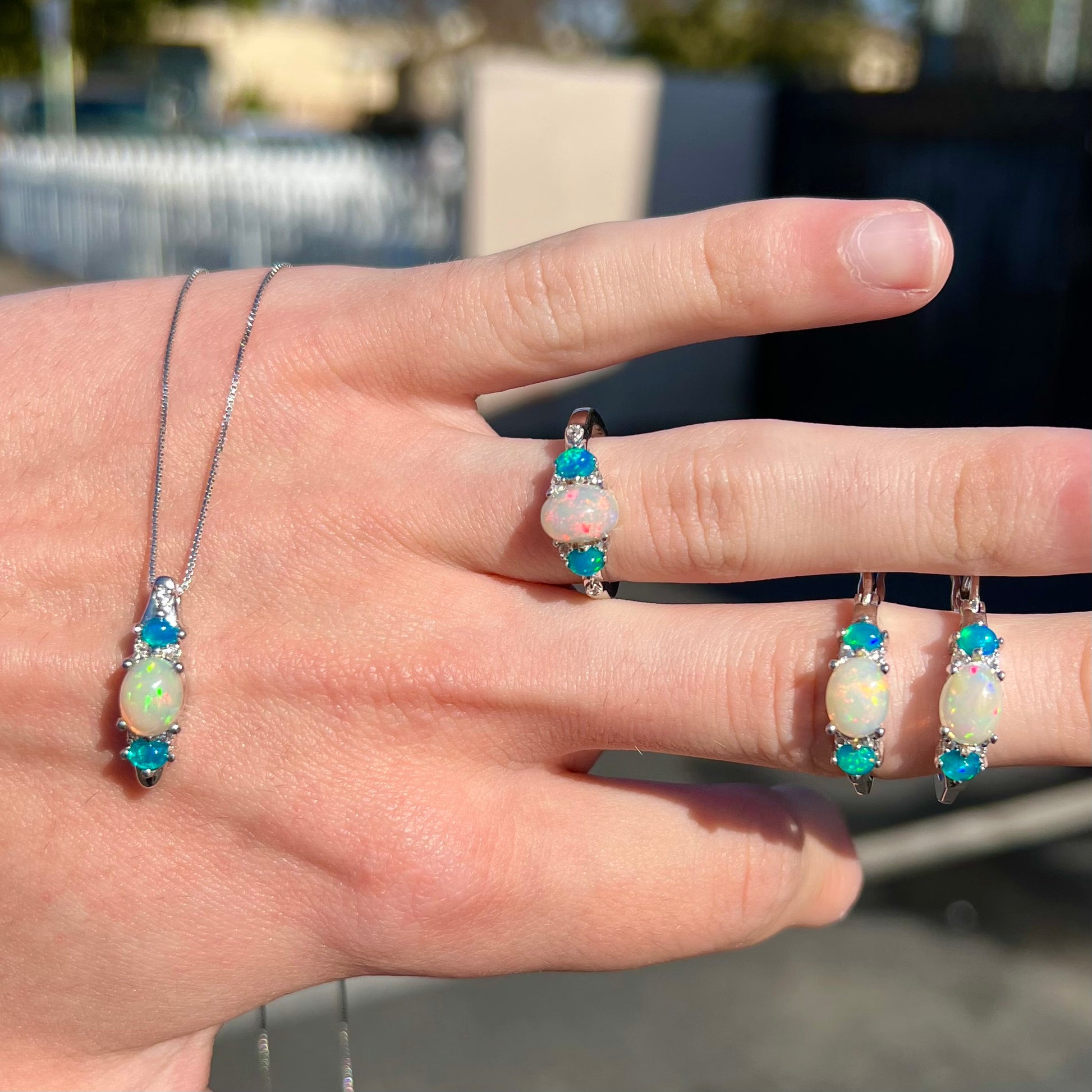 A sterling silver ring, earring, and necklace set made of Ethiopian opals and cubic zirconia.
