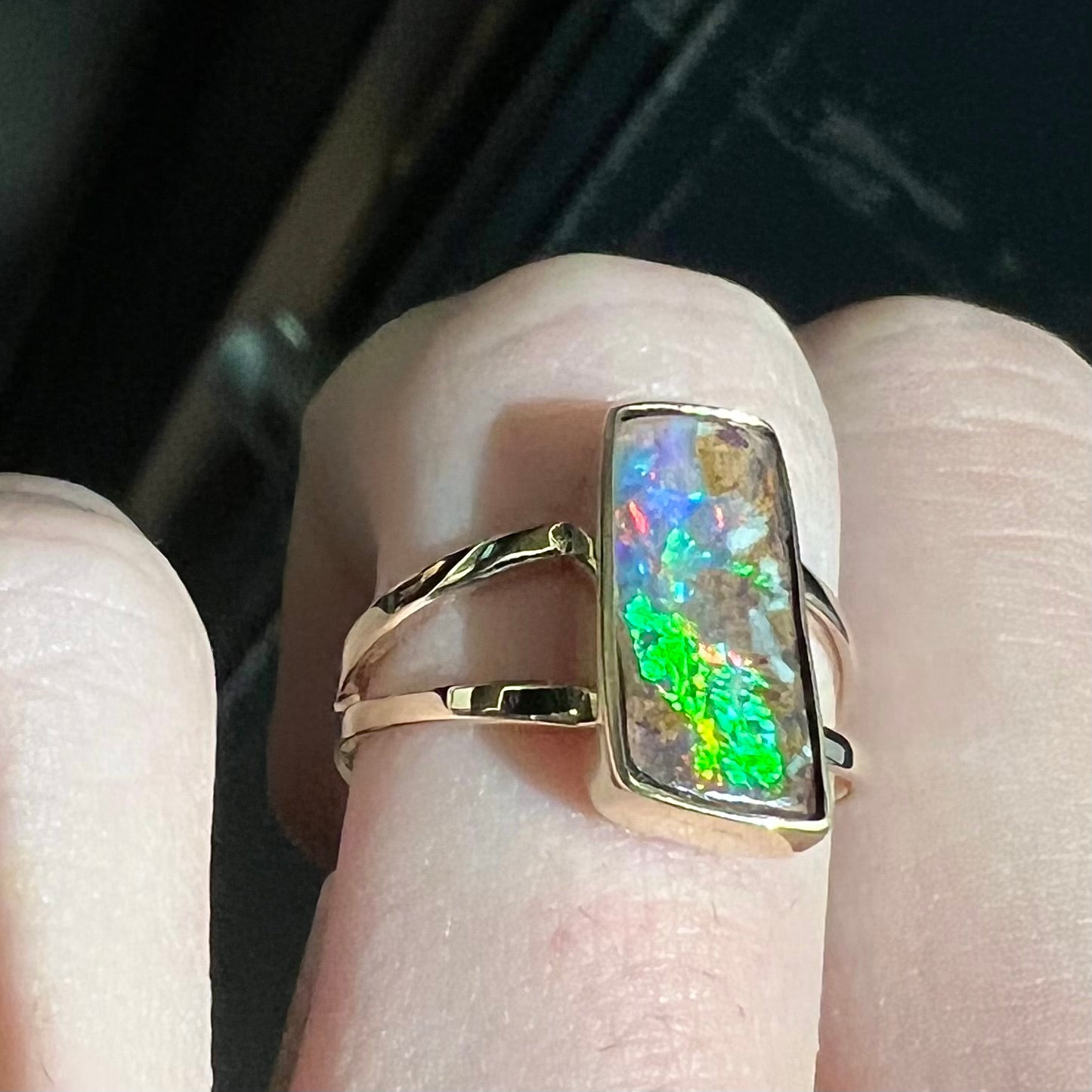 A handmade, split shank, yellow gold boulder opal solitaire ring.