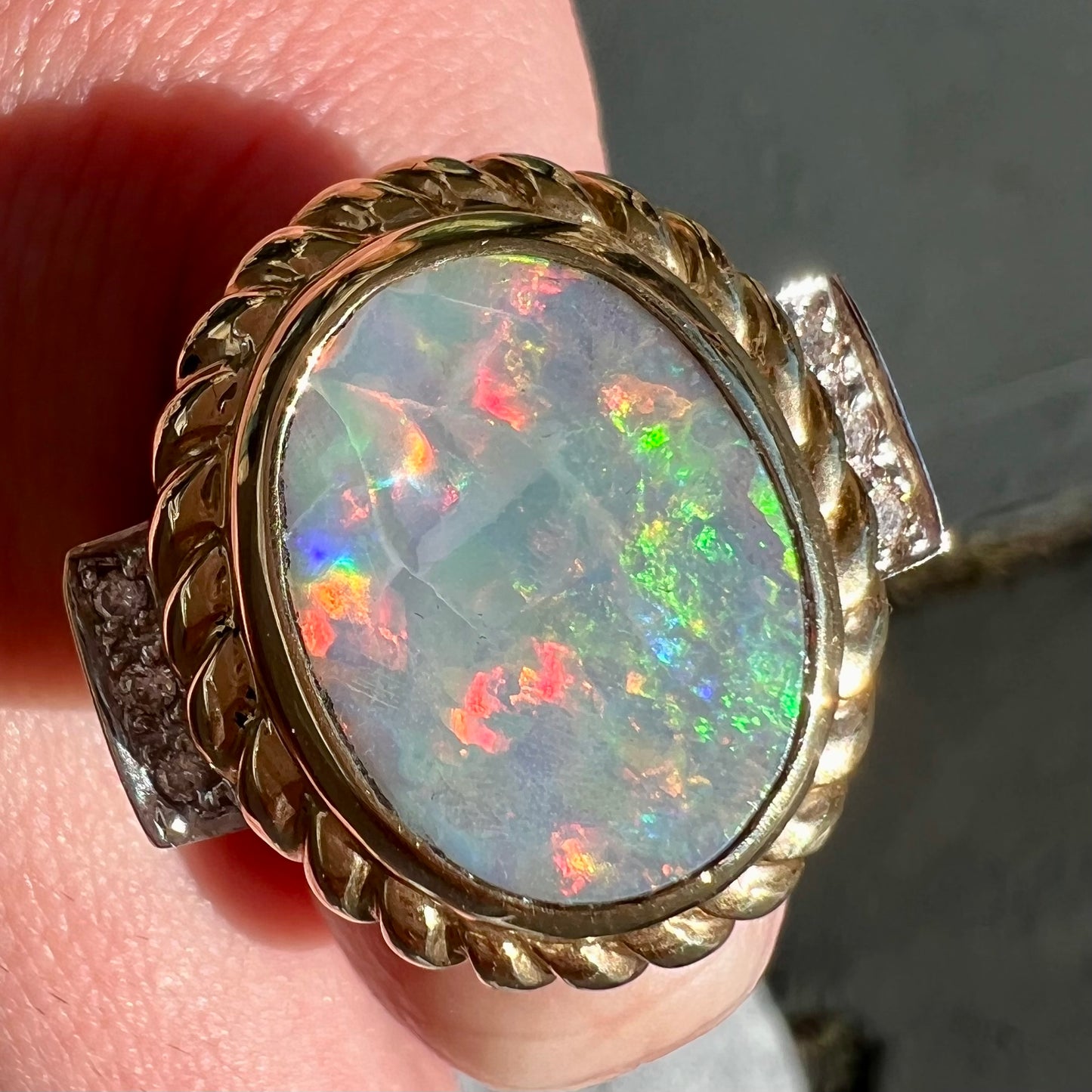 A ladies' Lightning Ridge semi-black opal ring cast in yellow gold and set with diamond accents.