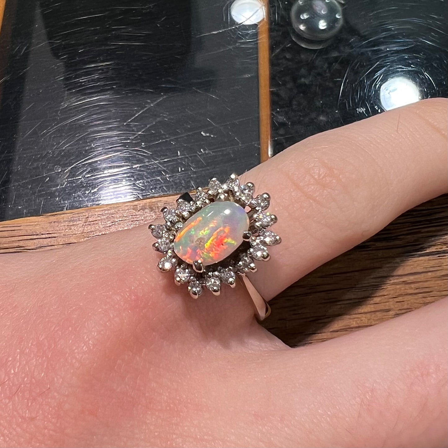 A white crystal opal ring cast in white gold with a halo of round cut diamonds.