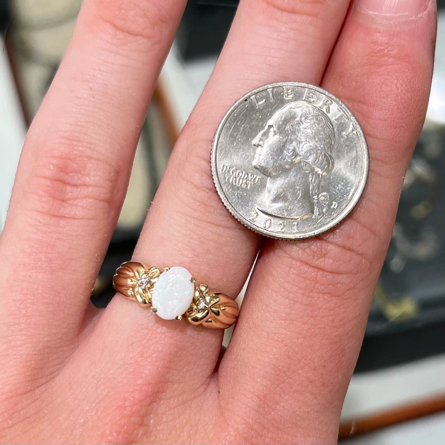 A ladies' yellow gold white crystal opal and diamond ring. The opal is prong set.