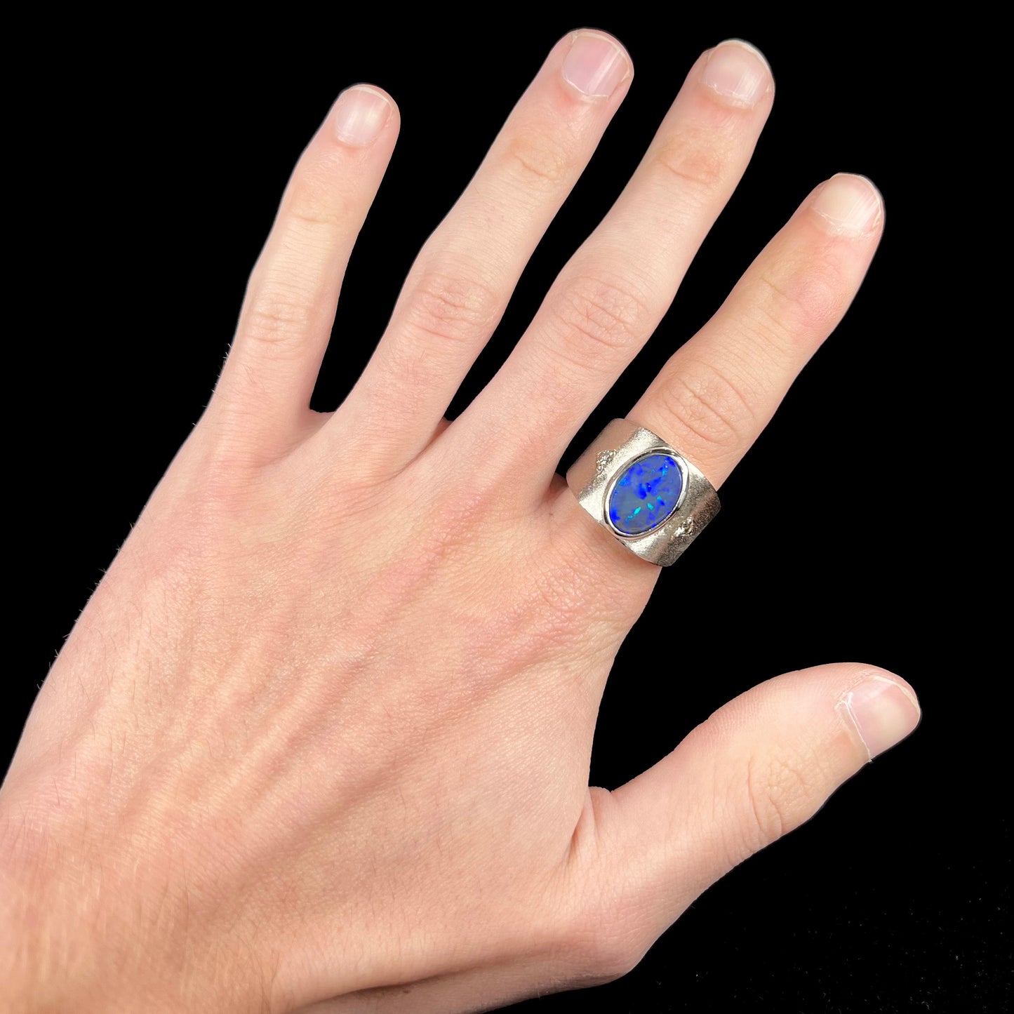 A men's natural black opal and diamond ring cast with a matte finish in white gold.