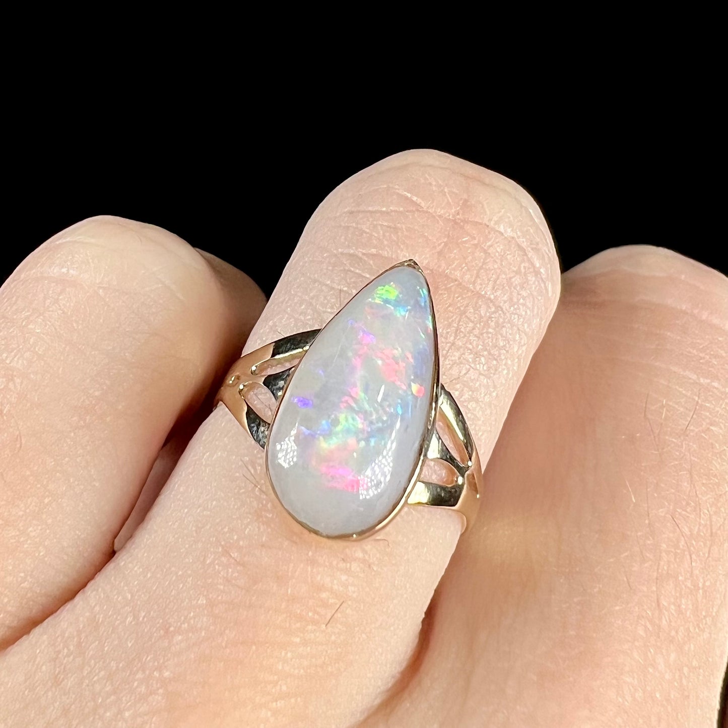 A ladies' pear shaped white crystal opal solitaire ring handmade in yellow gold.
