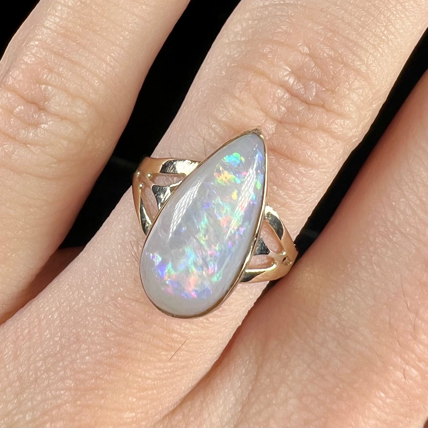 A ladies' pear shaped white crystal opal solitaire ring handmade in yellow gold.
