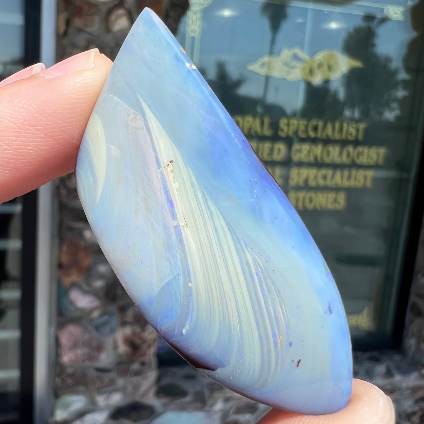 A loose, polished blue boulder opal stone from Queensland, Australia.