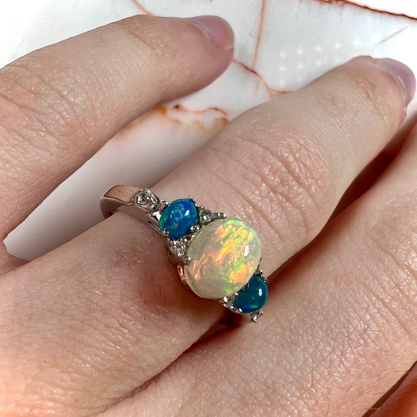 A sterling silver ring, earring, and necklace set made of Ethiopian opals and cubic zirconia.