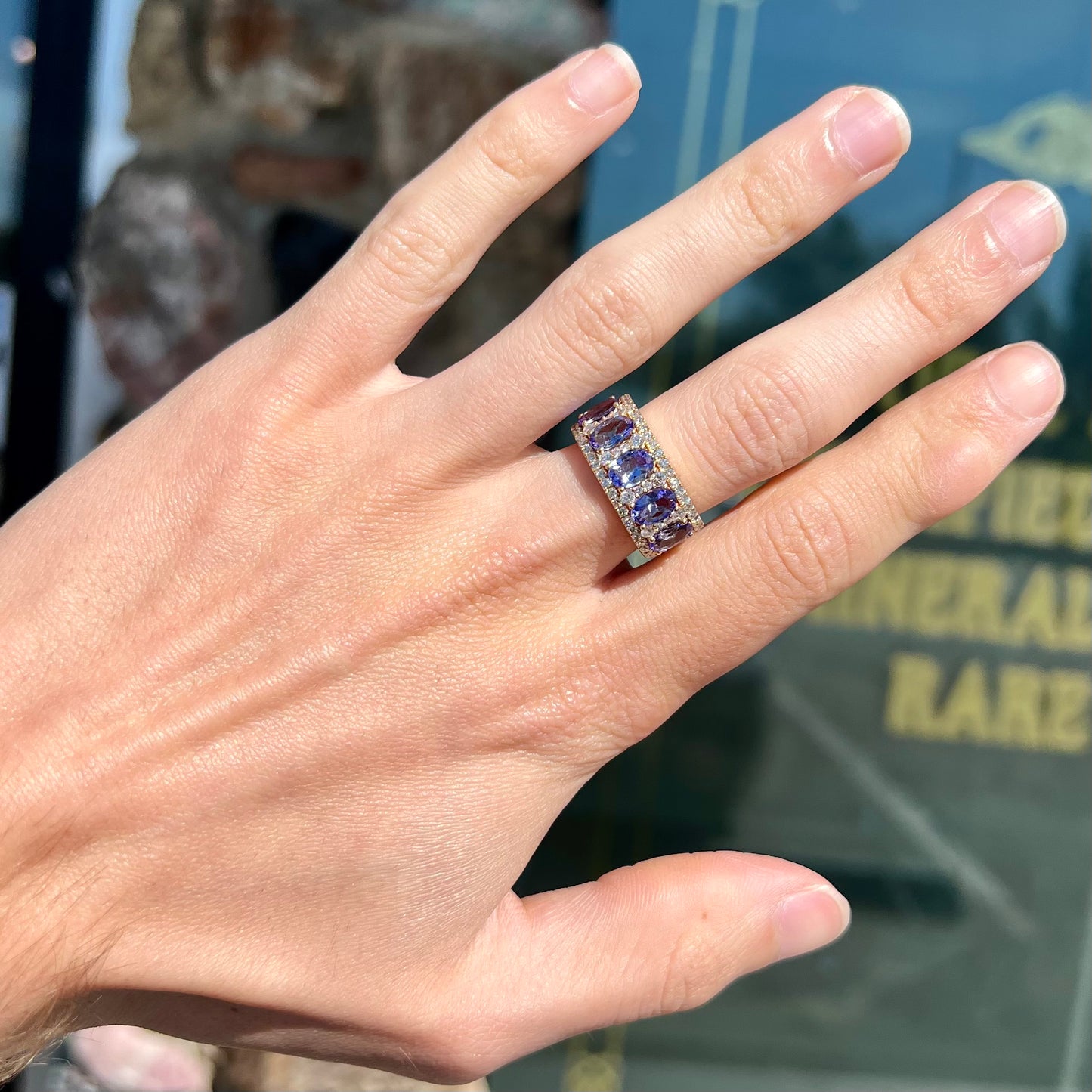 A gold and diamond ladies' band set with five oval cut tanzanite stones.