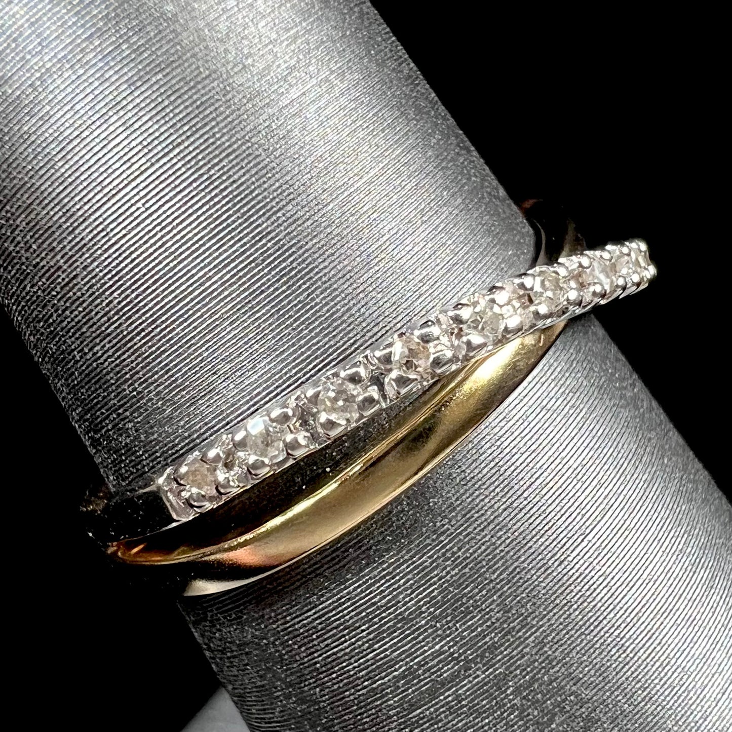 A ladies' two tone yellow and white gold twisted shank ring pave set with round single cut diamonds.