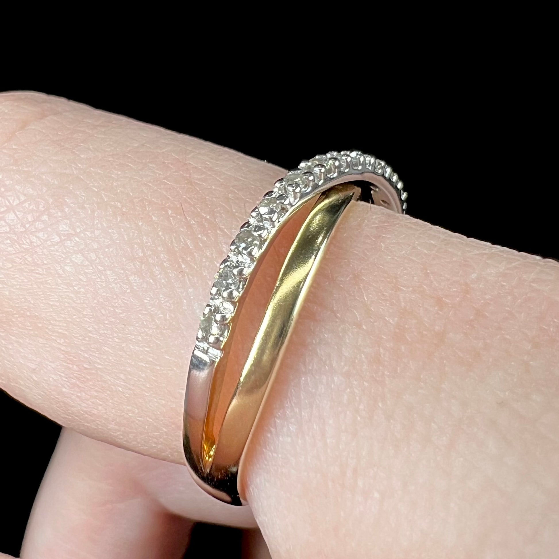 A ladies' two tone yellow and white gold twisted shank ring pave set with round single cut diamonds.