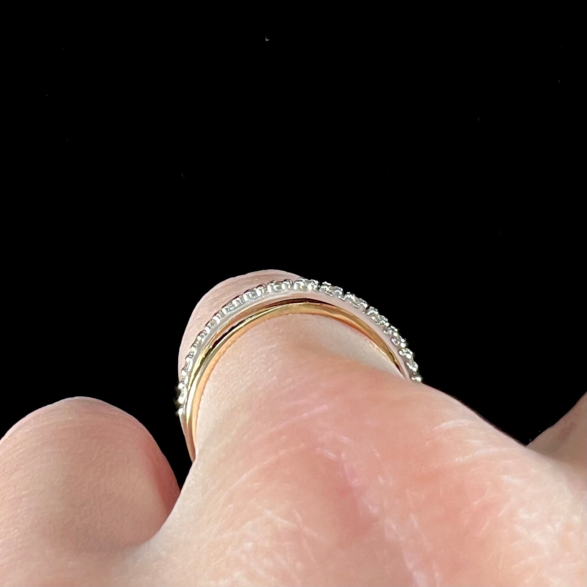 A ladies' two tone yellow and white gold twisted shank ring pave set with round single cut diamonds.