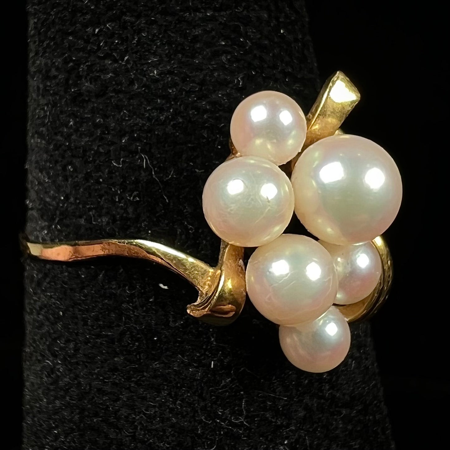 A yellow gold Akoya pearl cluster ring. The pearls are round with pink overtones and resemble bubbles.