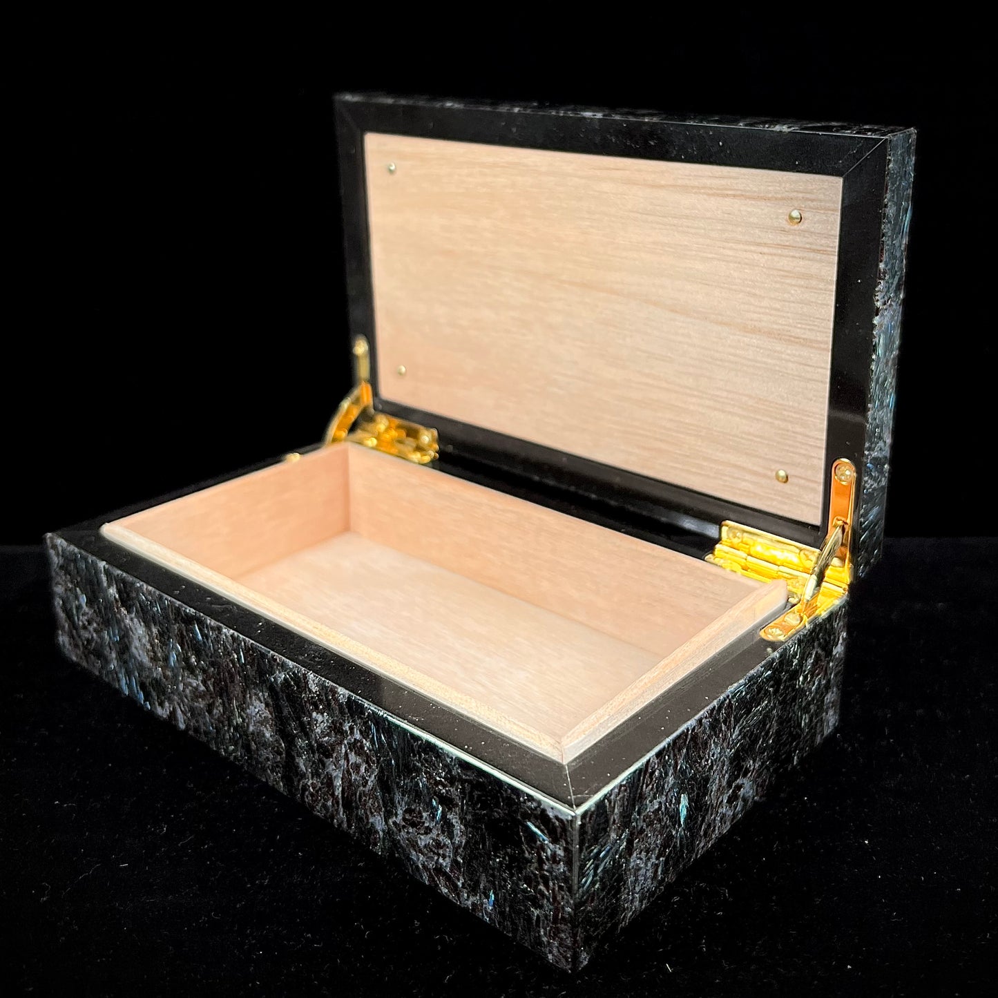 A custom stone box handmade by Gems Art Studio from polished red dinosaur bone and blue pietersite.