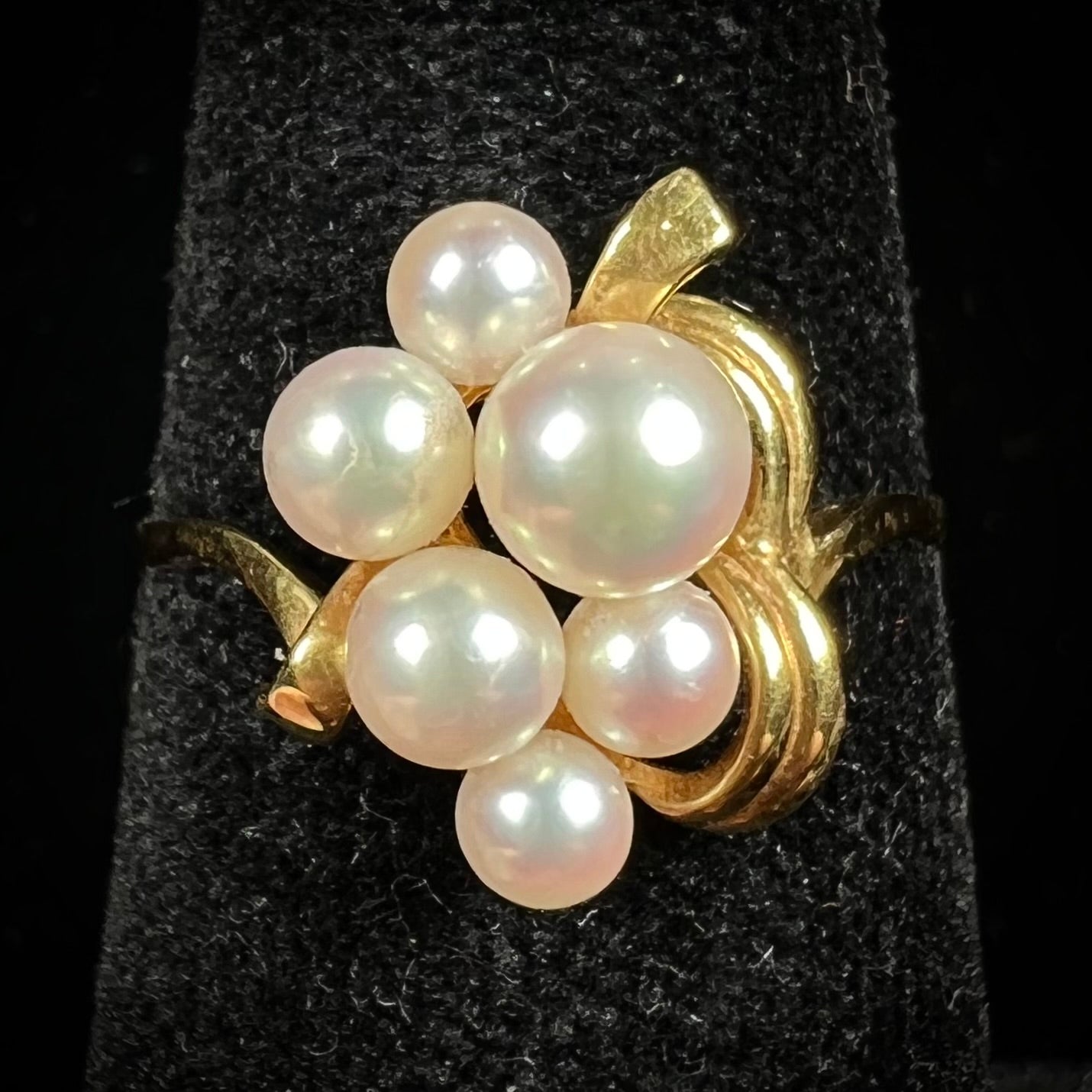 A yellow gold Akoya pearl cluster ring. The pearls are round with pink overtones and resemble bubbles.
