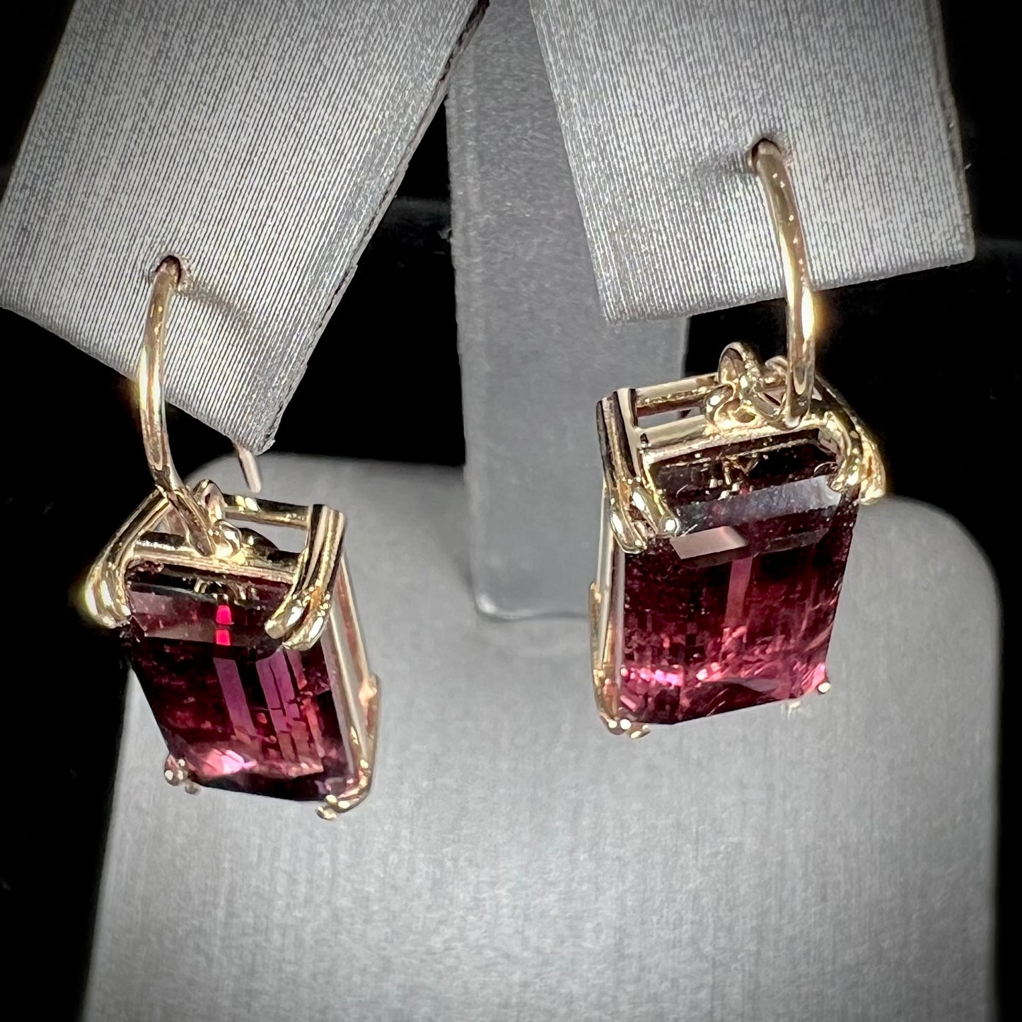 A pair of pink and magenta bicolor tourmaline dangle earrings handmade in 14kt yellow gold with basket settings and shepherd's hooks.