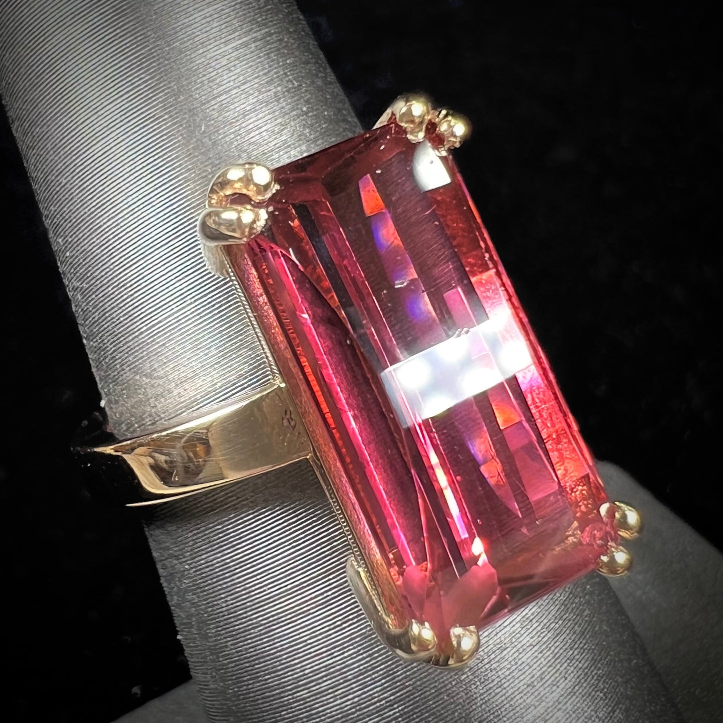 A handmade yellow gold solitaire ring set with a 7.91ct pinkish purple pixel cut tourmaline stone.