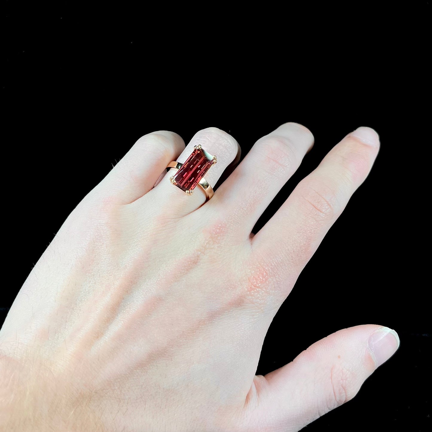 A handmade yellow gold solitaire ring set with a 7.91ct pinkish purple pixel cut tourmaline stone.