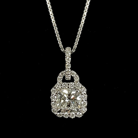 A ladies' platinum diamond halo necklace set with a 0.58ct cushion cut diamond on a box chain.
