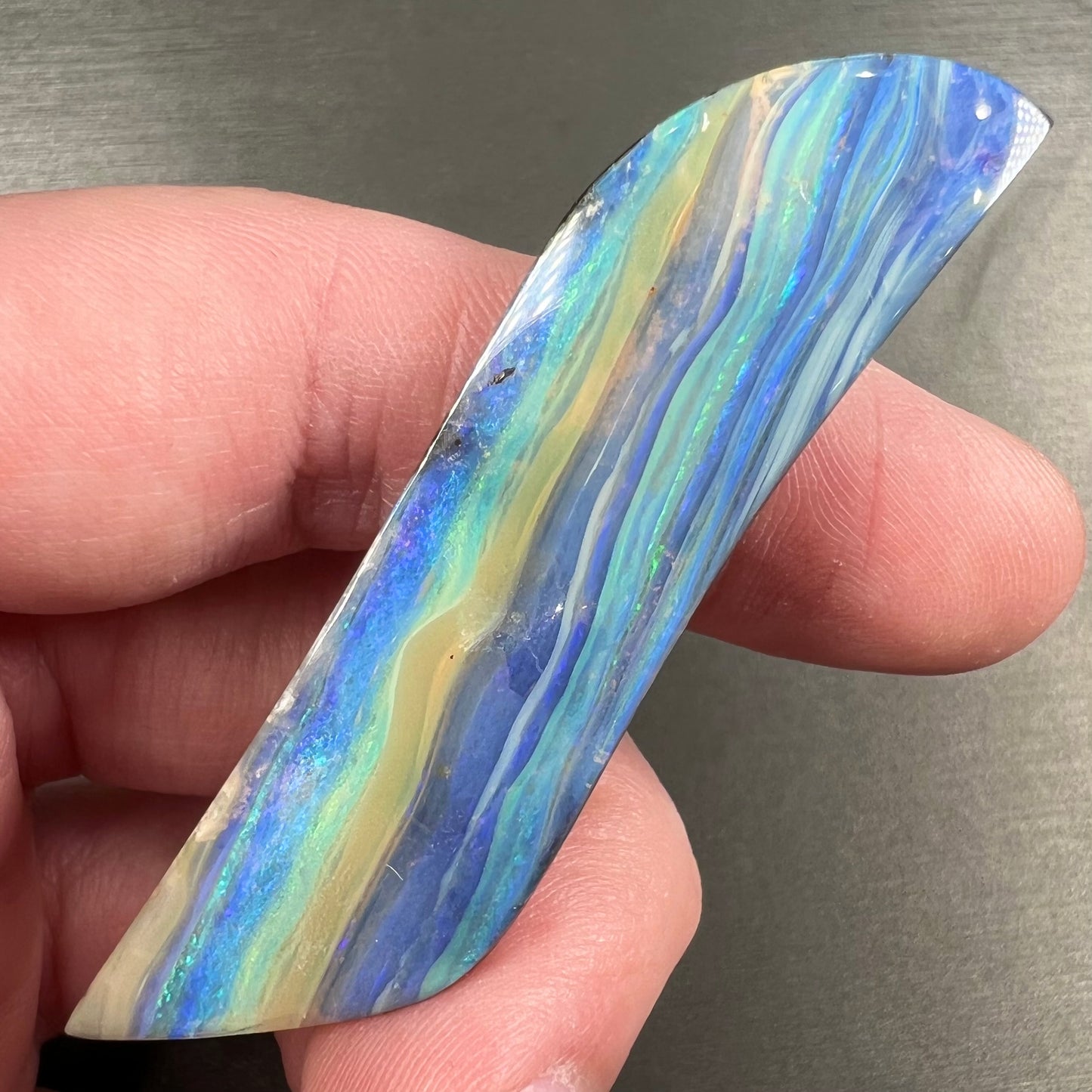 A large, loose, polished Quilpie boulder opal stone from Queensland, Australia. The stone is blue.