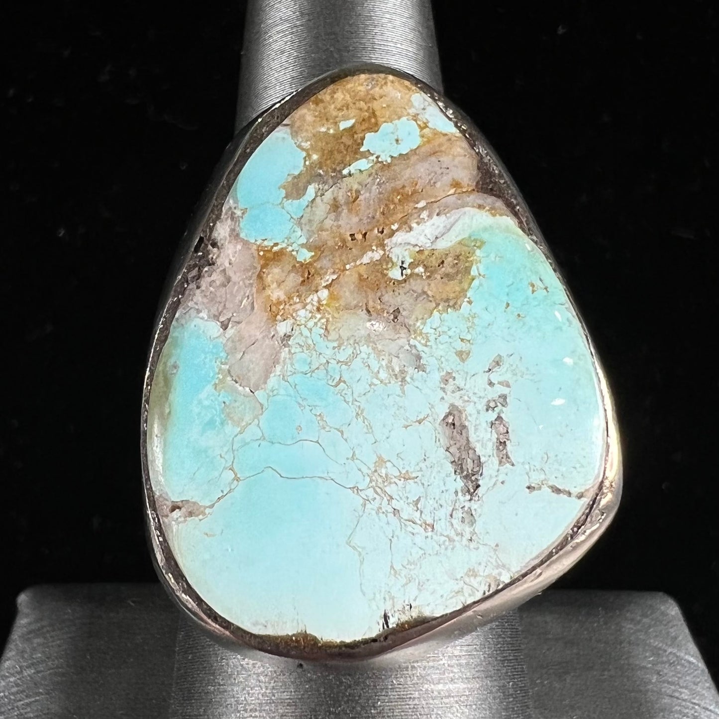 A men's sterling silver ring set with a powder blue turquoise stone. The ring is rustic style.
