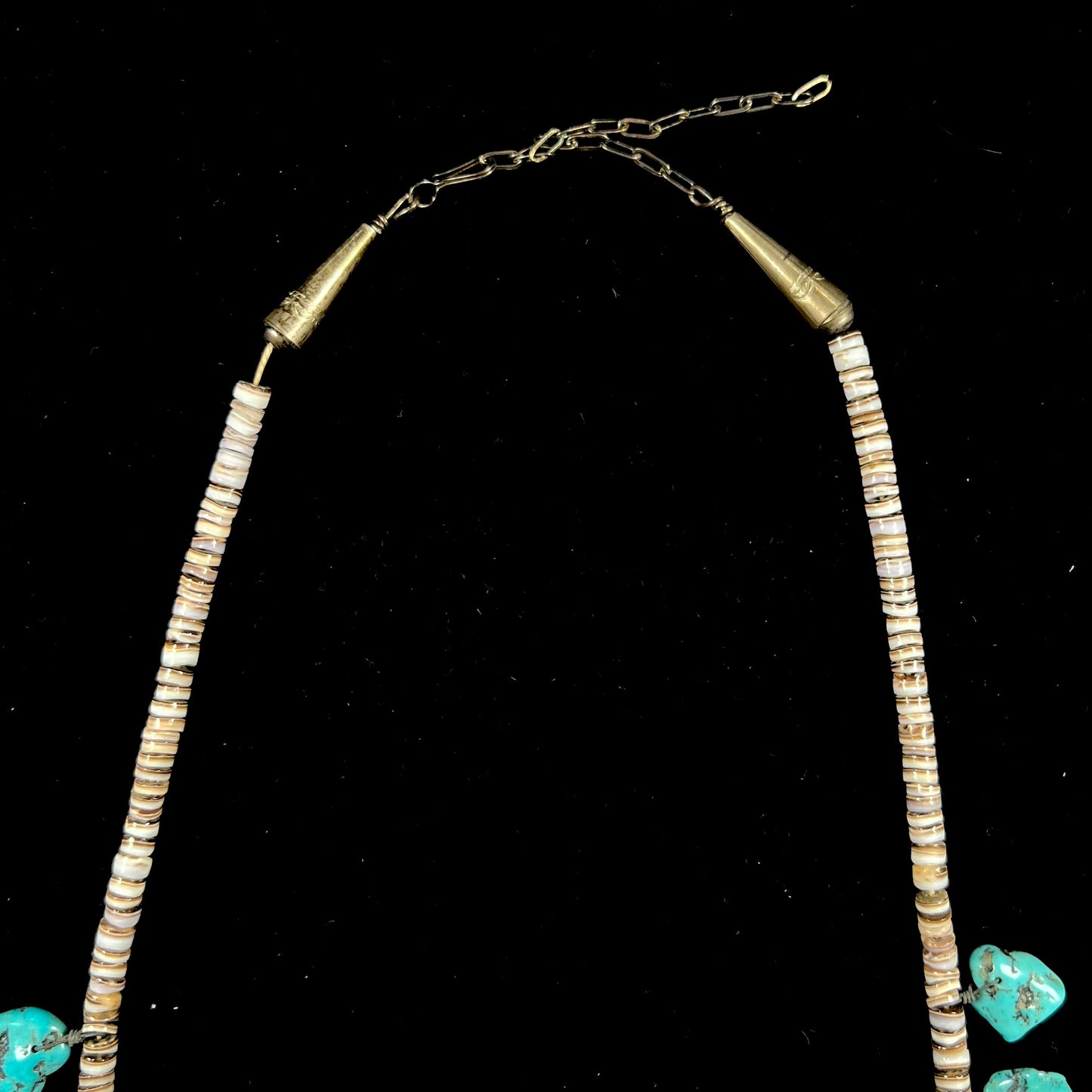 A Santo Domingo puka shell bead necklace with drilled turquoise nuggets attached.