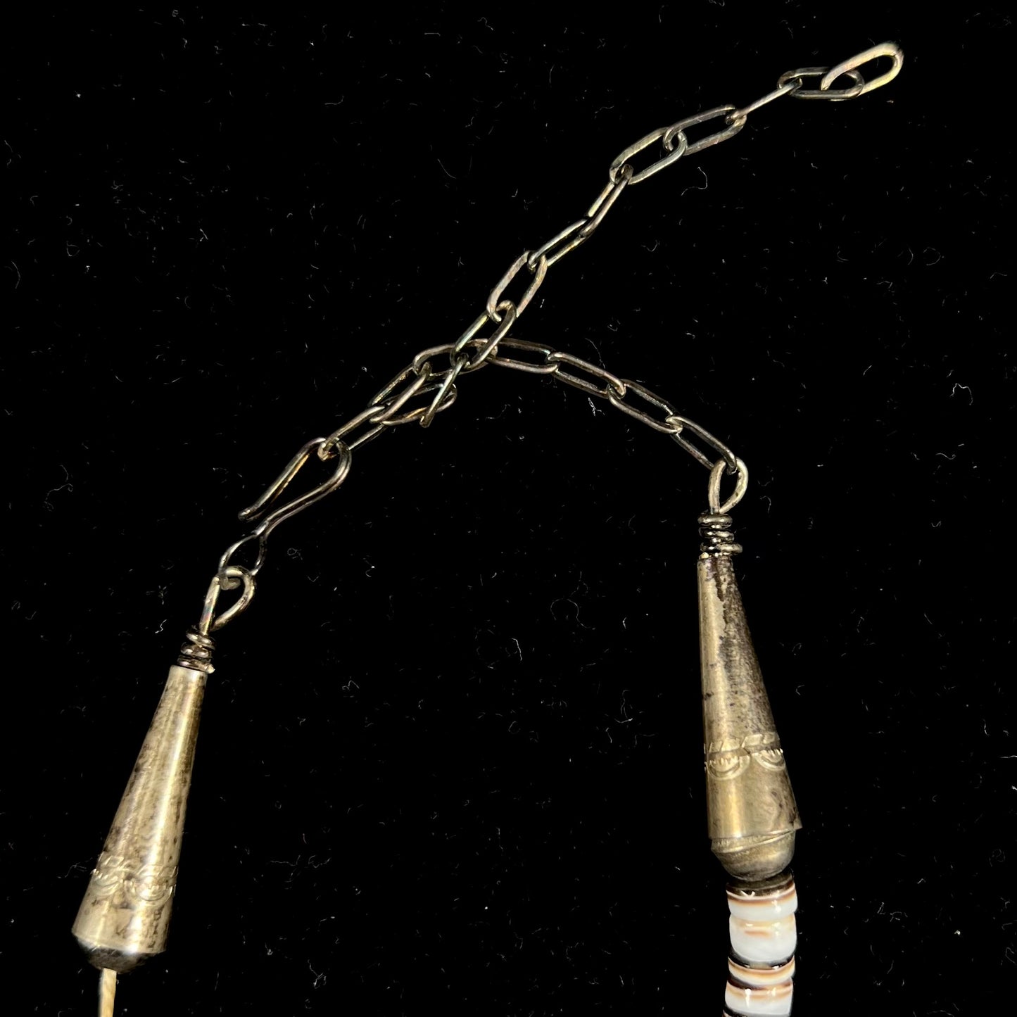 A Santo Domingo puka shell bead necklace with drilled turquoise nuggets attached.