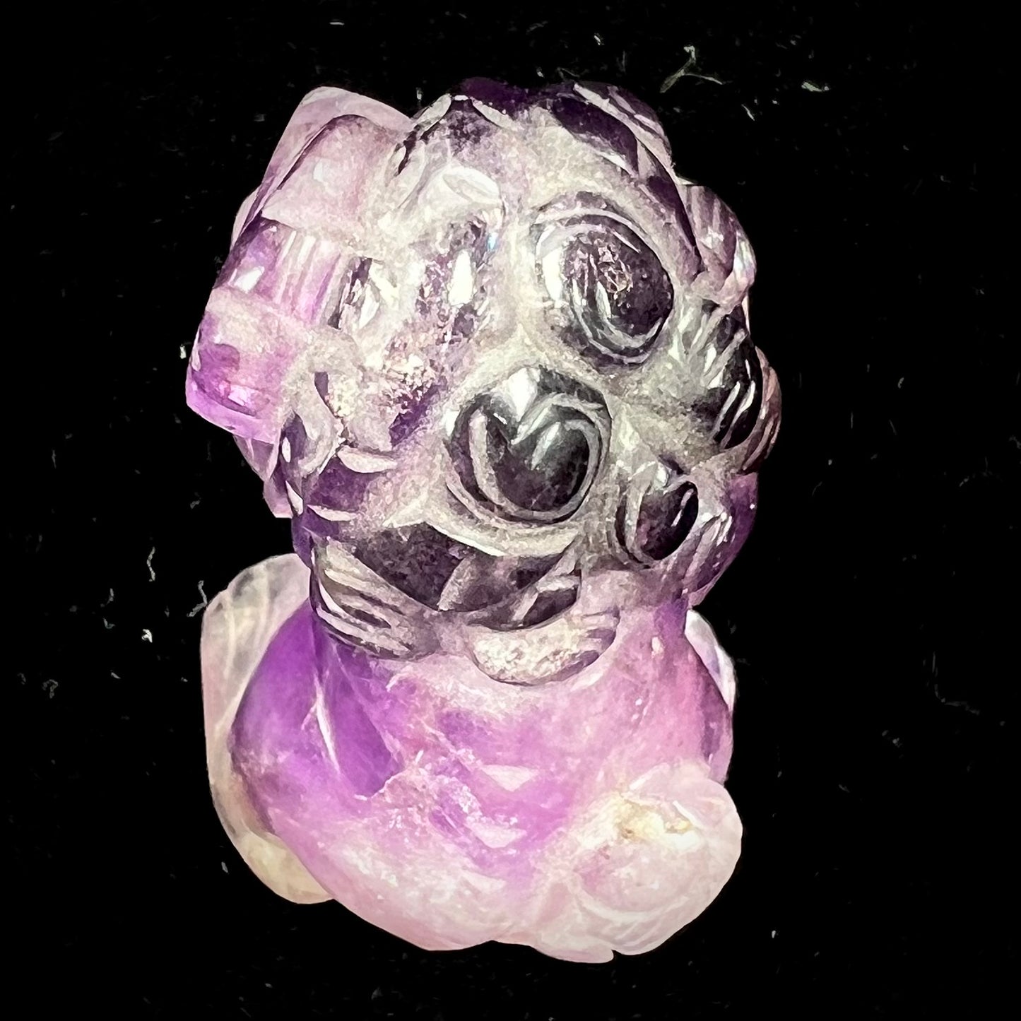 A stone foo dog carving carved from a purple Brazilian amethyst crystal.