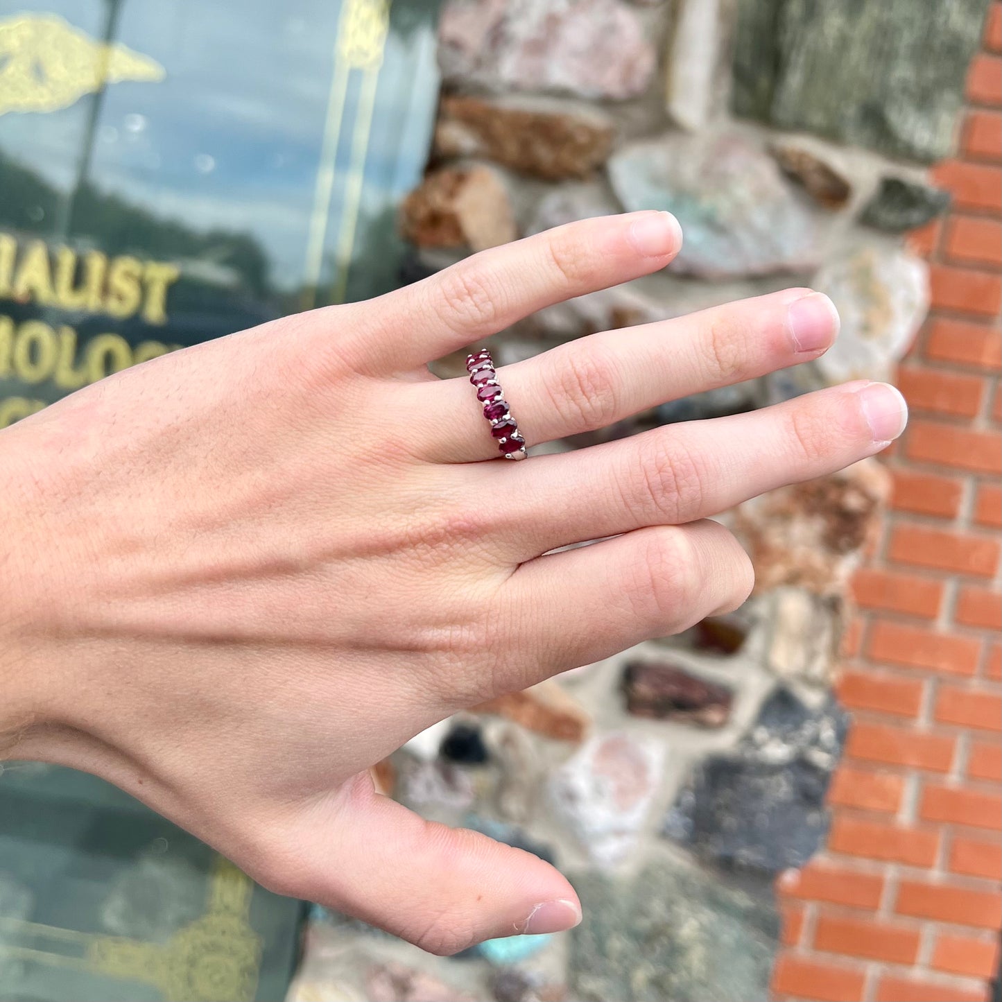 A sterling silver band set with 7 oval cut, purple rhodolite garnet stones.