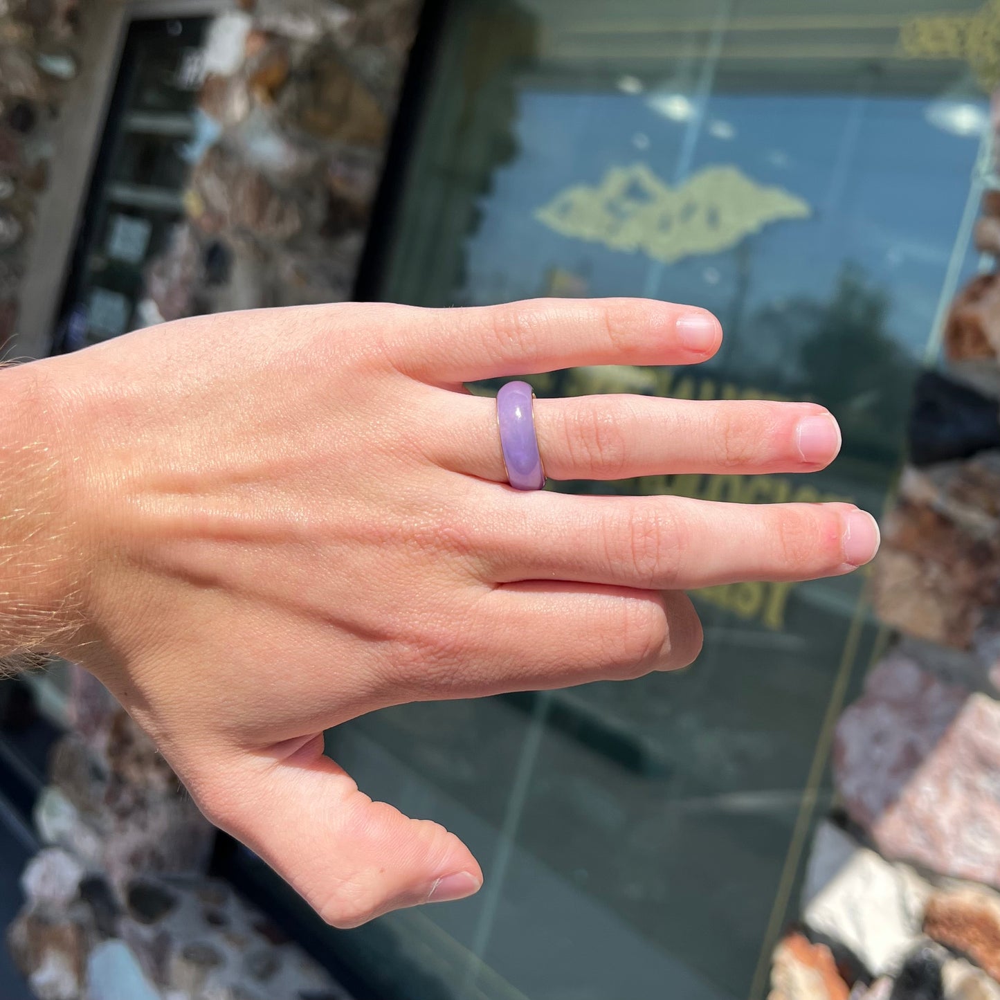 A stone ring carved from purple jadeite jade and mounted on a gold band.
