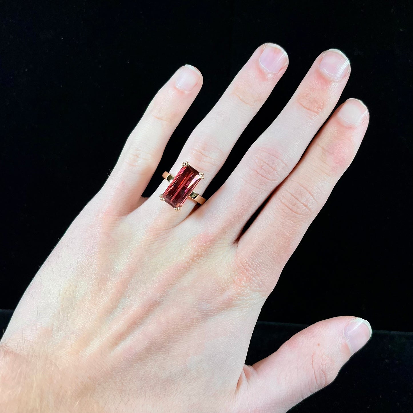 A handmade yellow gold solitaire ring set with a 7.91ct pinkish purple pixel cut tourmaline stone.