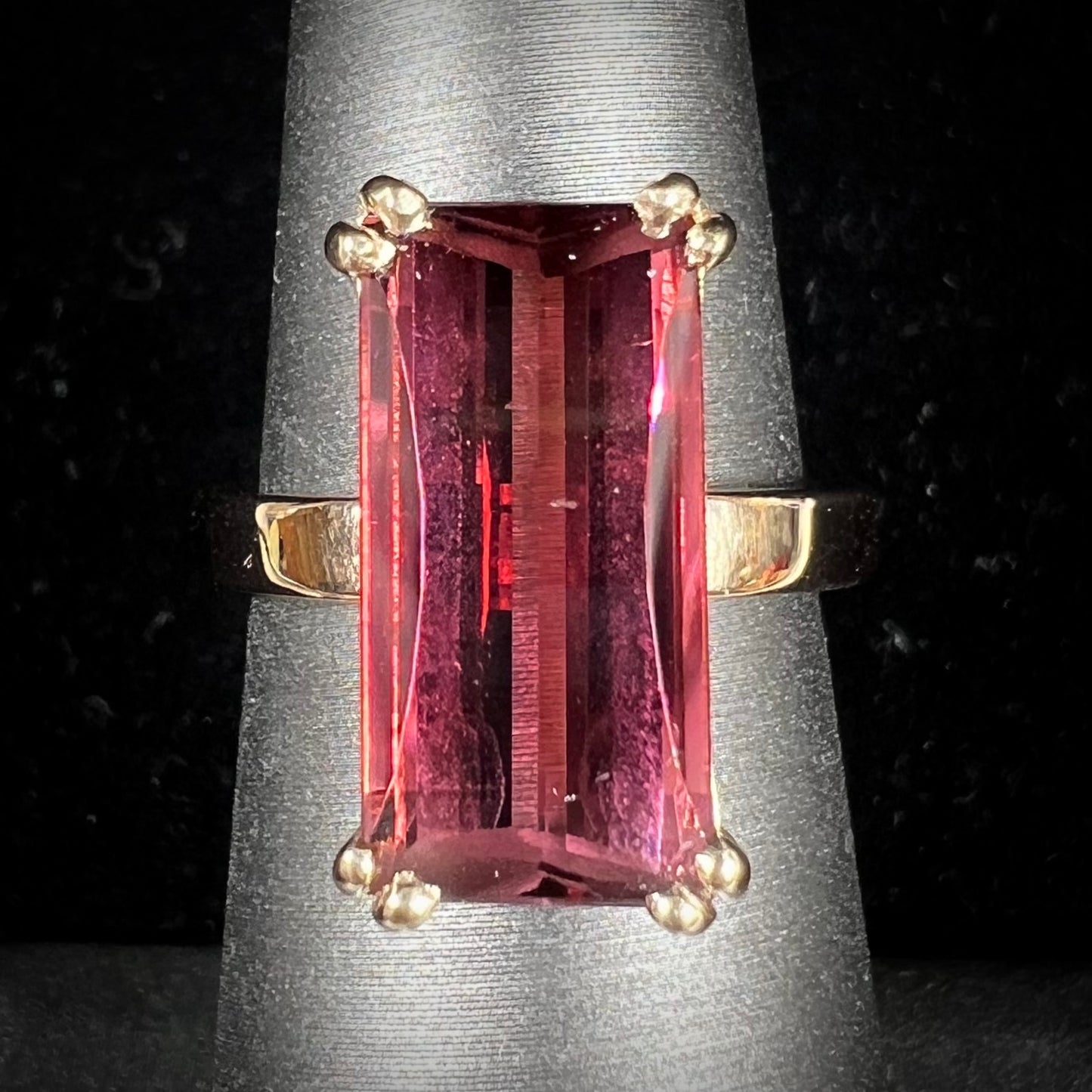 A handmade yellow gold solitaire ring set with a 7.91ct pinkish purple pixel cut tourmaline stone.