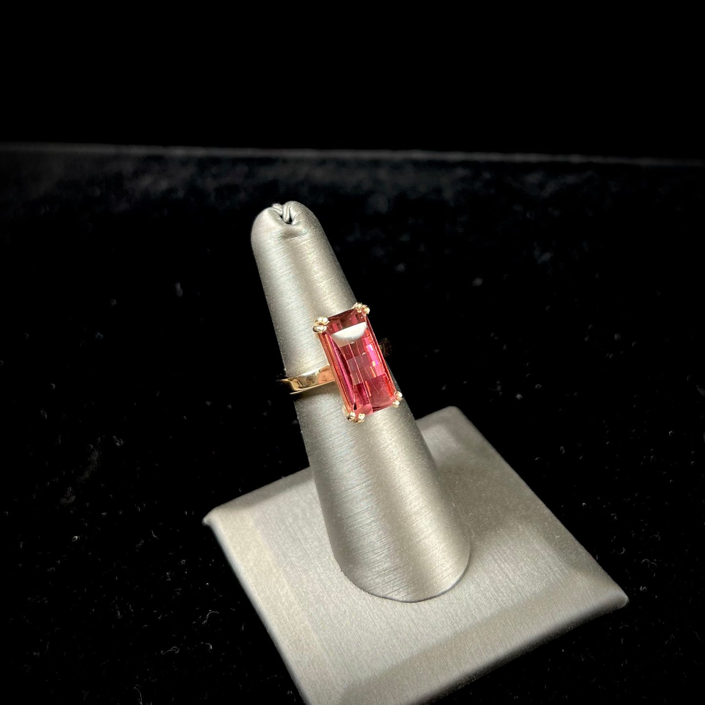 A handmade yellow gold solitaire ring set with a 7.91ct pinkish purple pixel cut tourmaline stone.