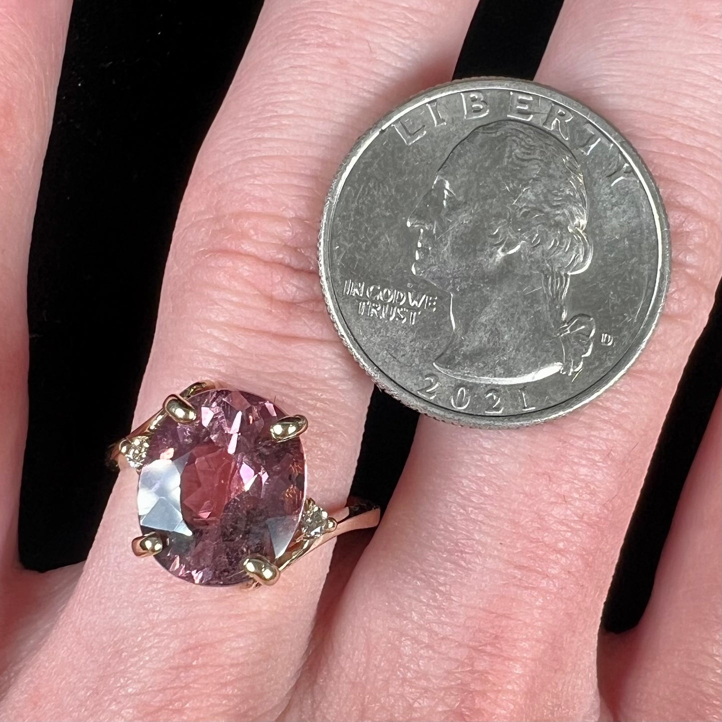 A ladies' yellow gold, faceted oval cut purple tourmaline ring set with diamond accents.