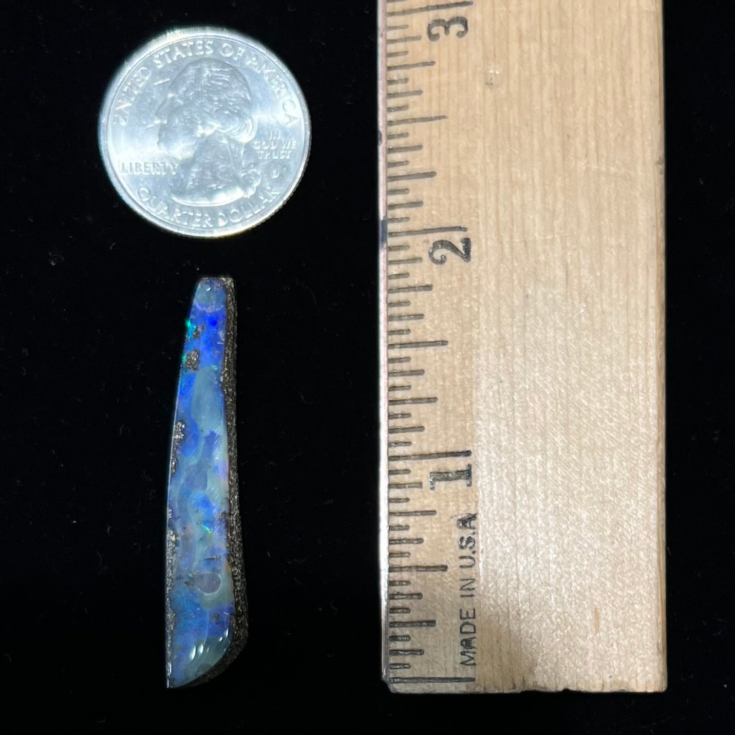A loose, polished Quilpie boulder opal stone from Australia. The stone is predominantly blue.