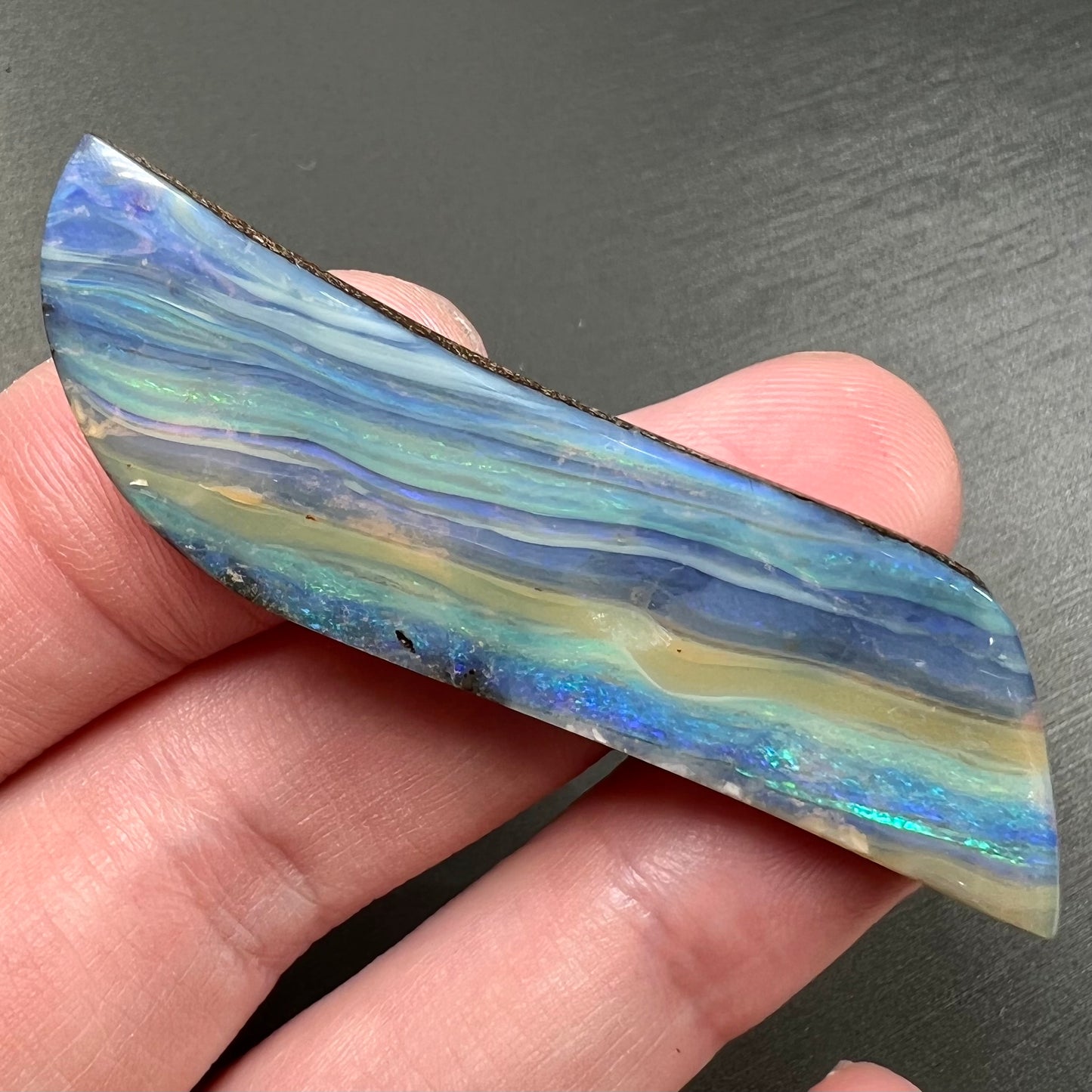 A large, loose, polished Quilpie boulder opal stone from Queensland, Australia. The stone is blue.