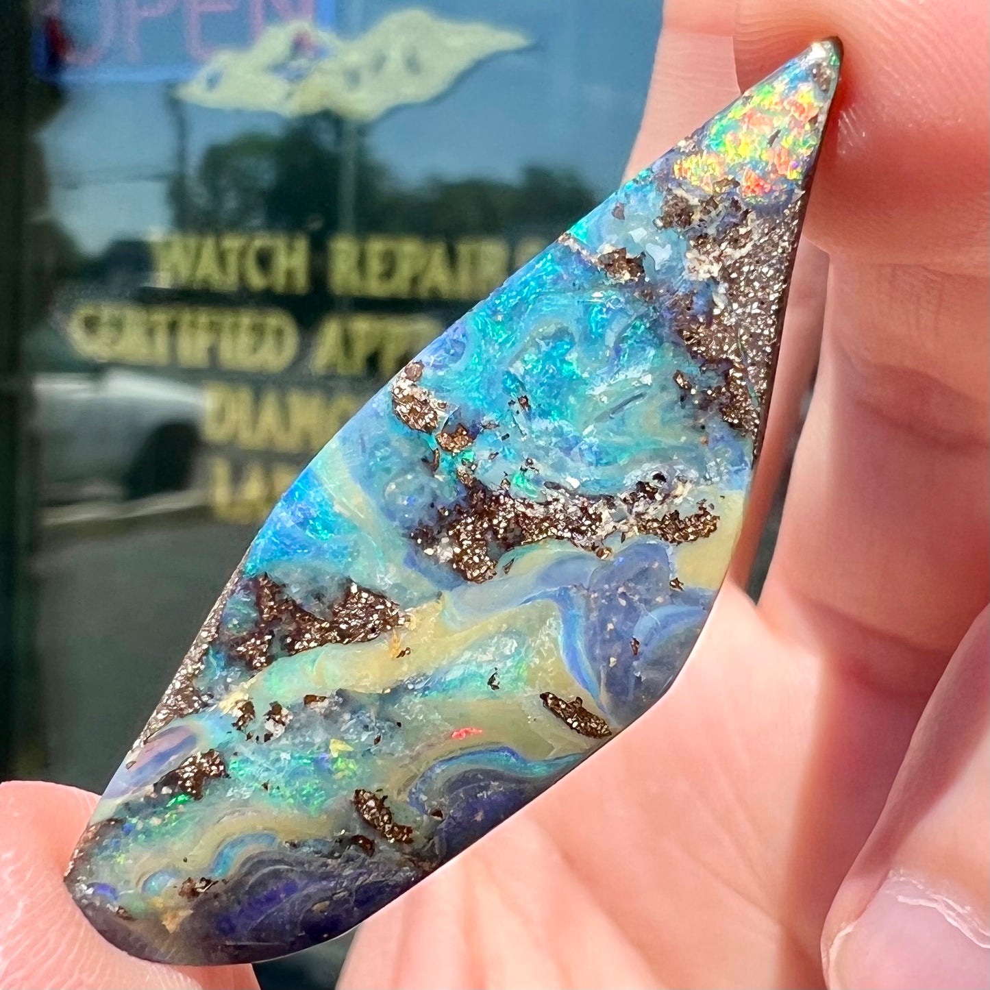 A loose Quilpie boulder opal stone. The stone is blue and has a bright rainbow tip.