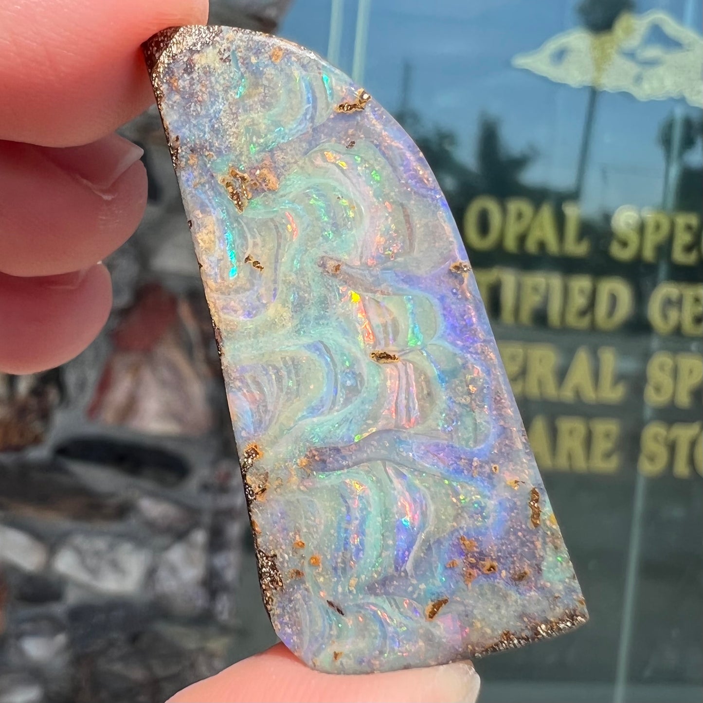A loose, freeform cut, natural boulder opal stone from Quilpie, Australia.