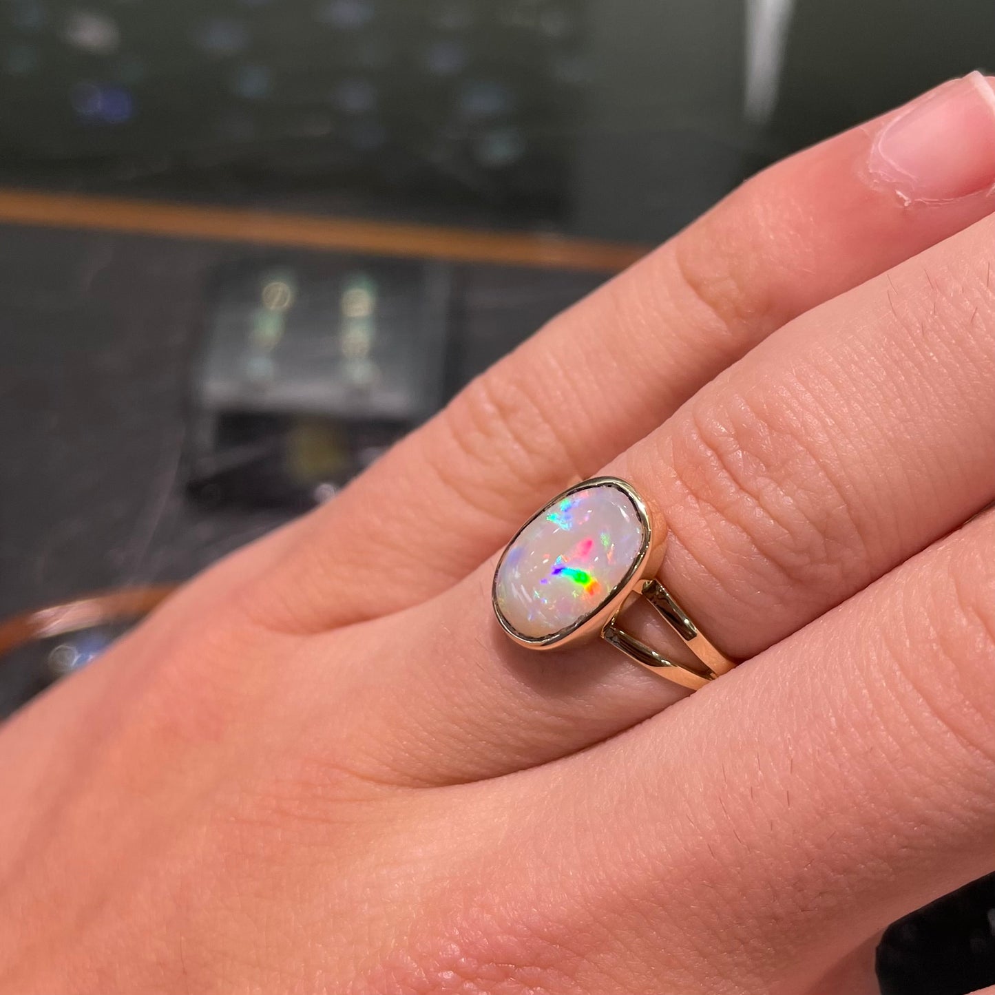 A handmade split shank white opal solitaire ring in yellow gold.