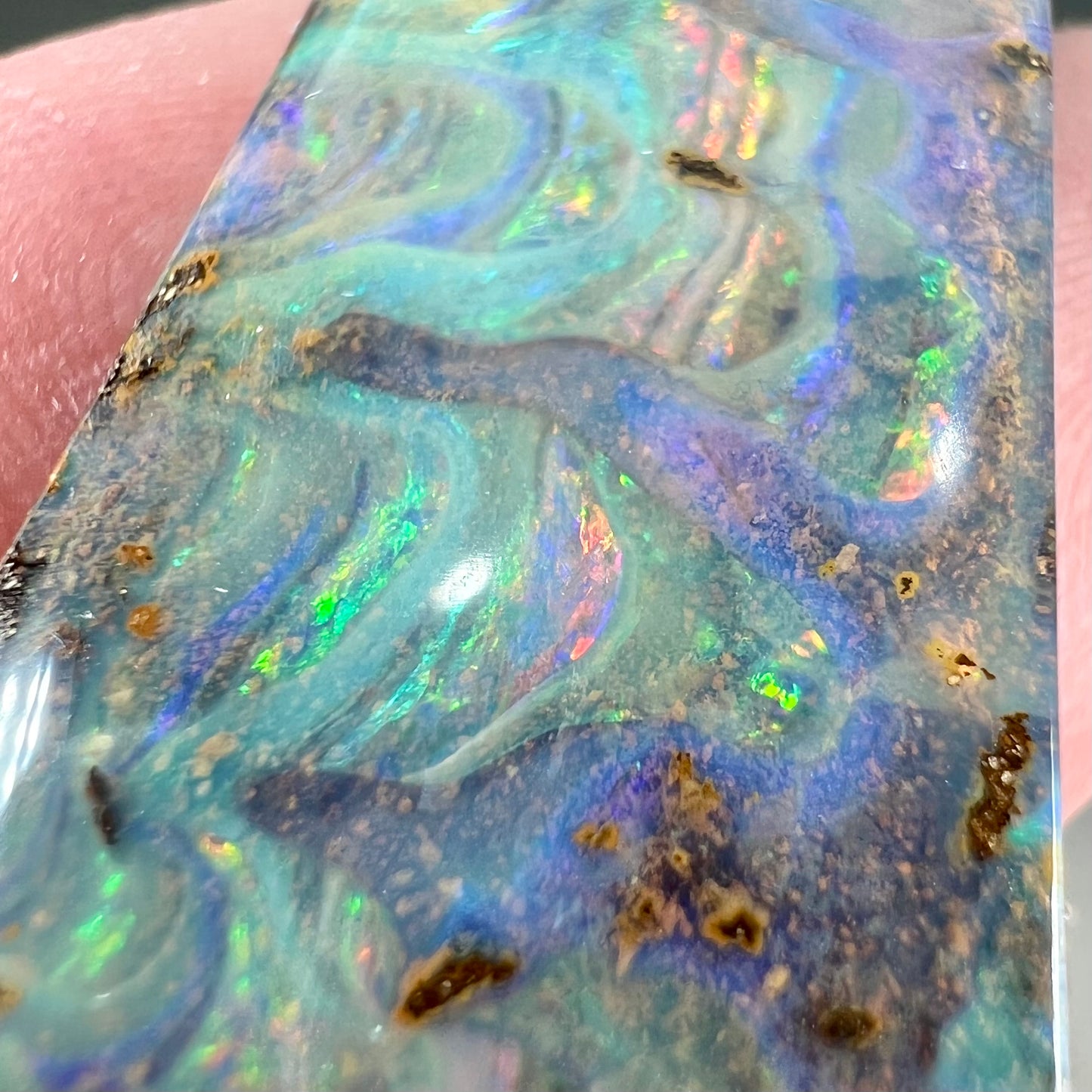 A loose, freeform cut, natural boulder opal stone from Quilpie, Australia.